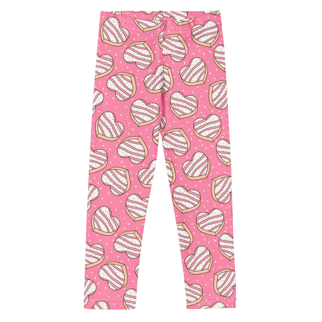 Girls pink buttery soft leggings with a heart-shaped cookie pattern featuring white icing stripes and brown outlines