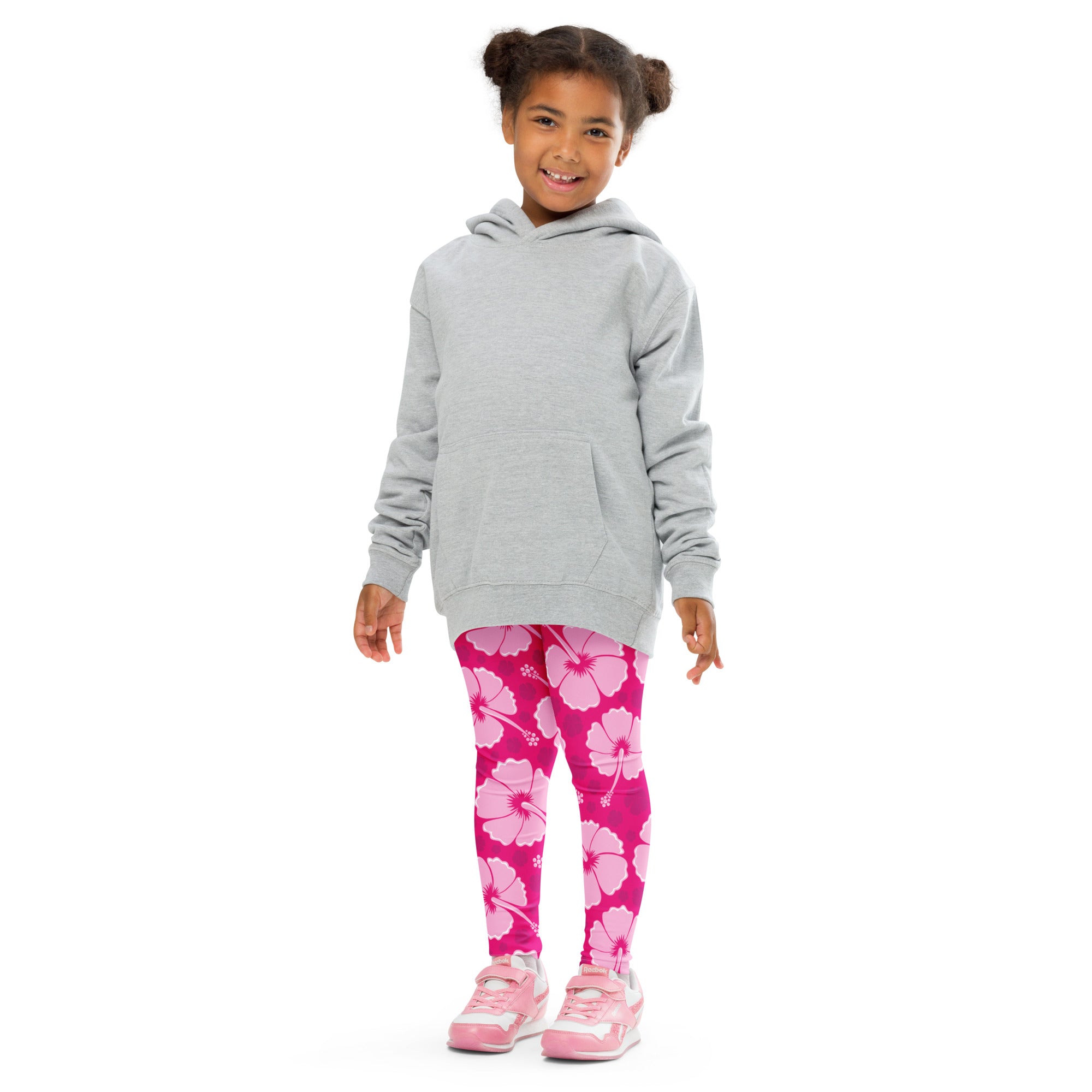 A child wearing girls tropical pink hibiscus buttery soft leggings with large flower patterns paired with a gray hoodie
