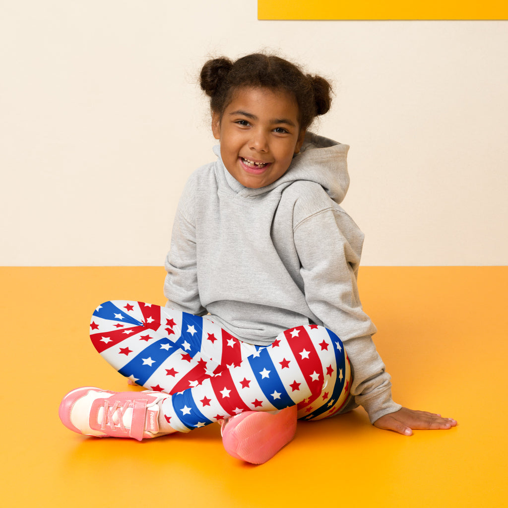 A child wearing kids red white and blue stars and stripes buttery soft leggings with a gray hoodie