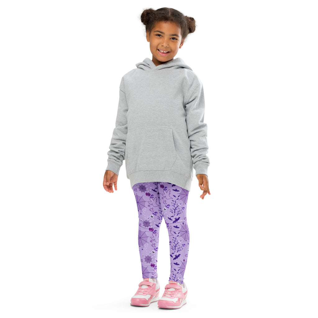 A child wearing kids purple halloween buttery soft leggings with spiderweb and bat patterns paired with a gray hoodie
