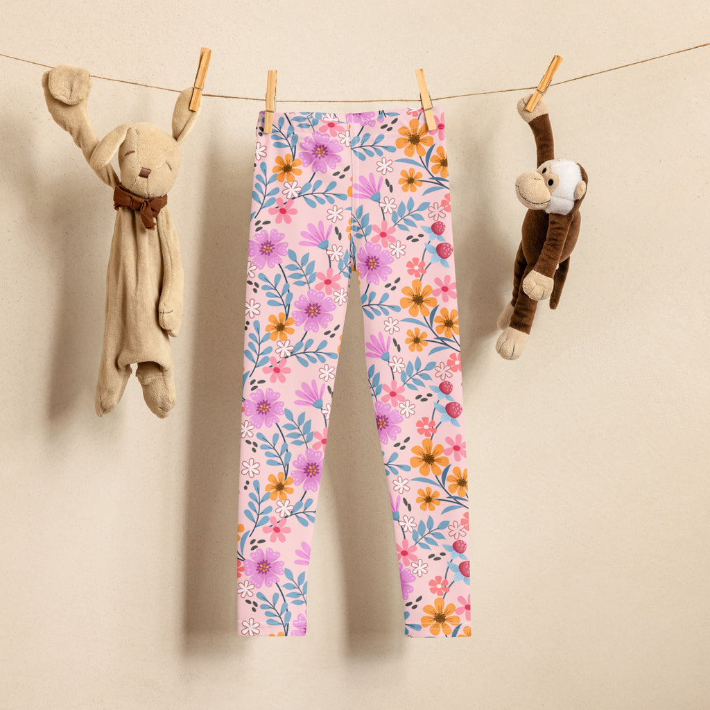 Girls pink floral buttery soft leggings featuring a light pink background with purple orange and white flowers