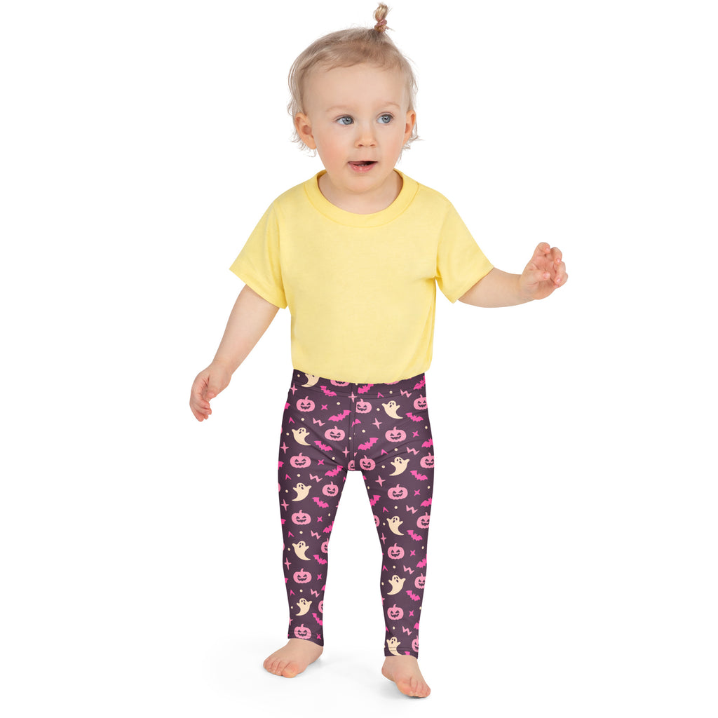 A child wearing girls purple and pink halloween buttery soft leggings with pink pumpkins ghosts bats and stars