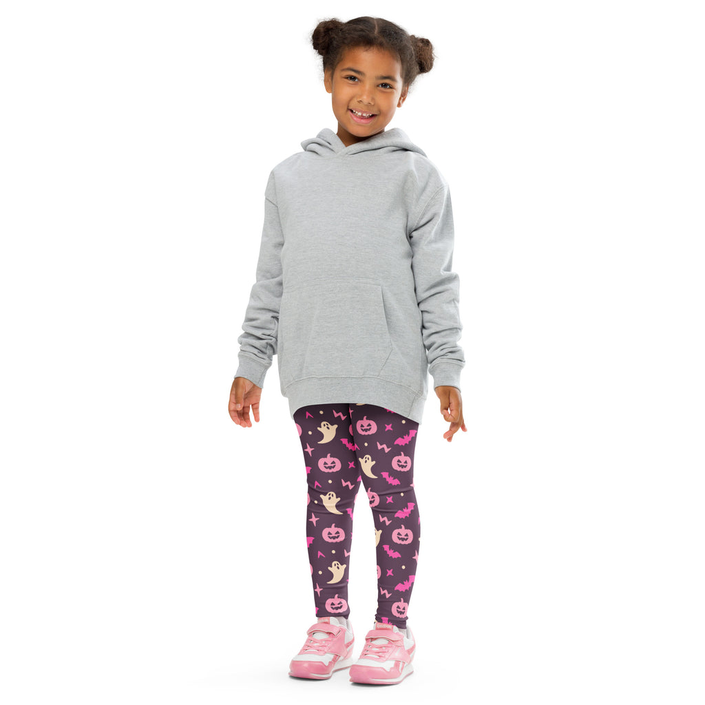 Child wearing a gray hooded sweatshirt with long sleeves and front pocket paired with girls purple and pink buttery soft halloween leggings