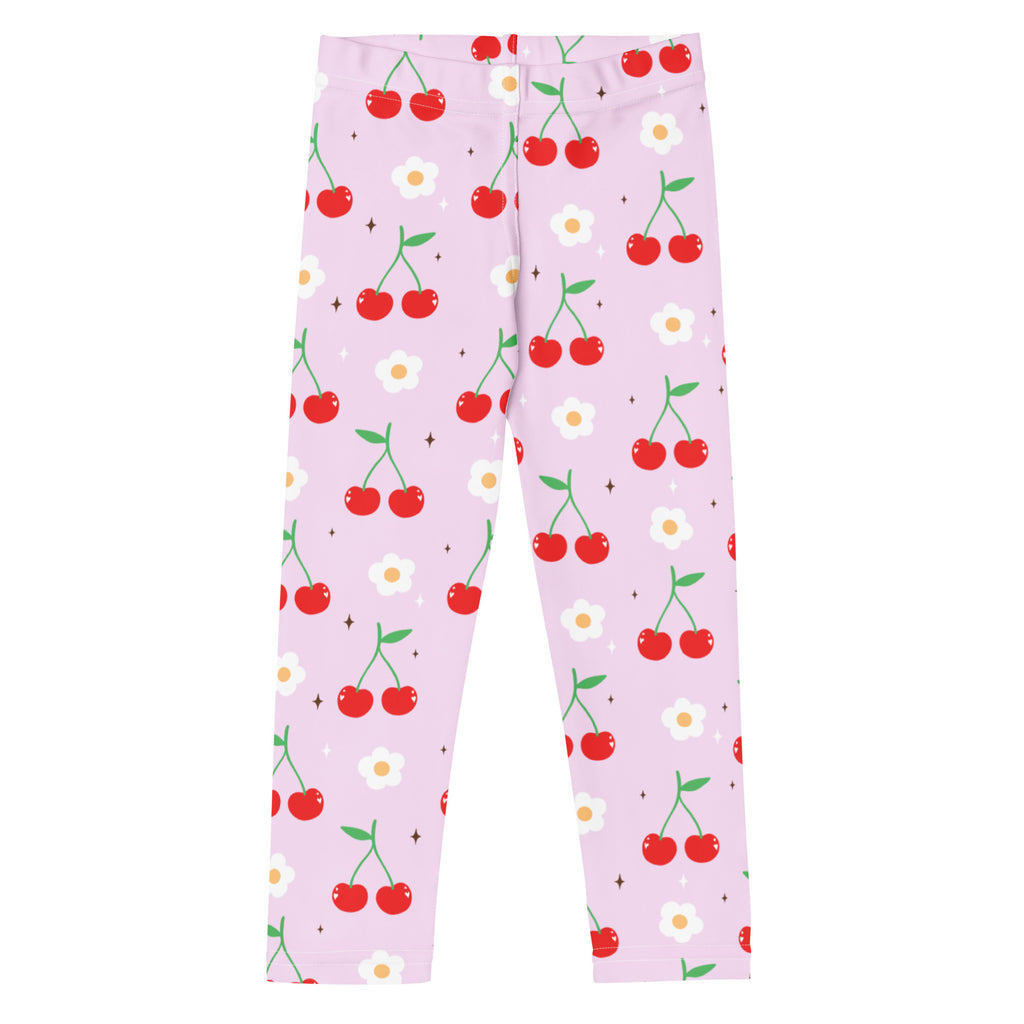 Girls pink buttery soft leggings with a playful red cherry and white daisy pattern on a light pink background