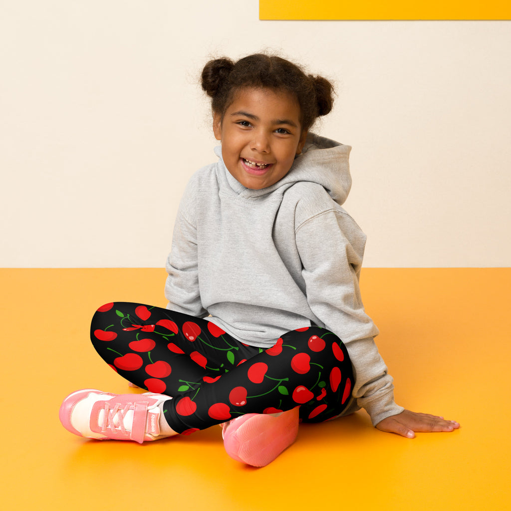 Girls black cherry buttery soft leggings featuring vibrant red cherry pattern on black fabric