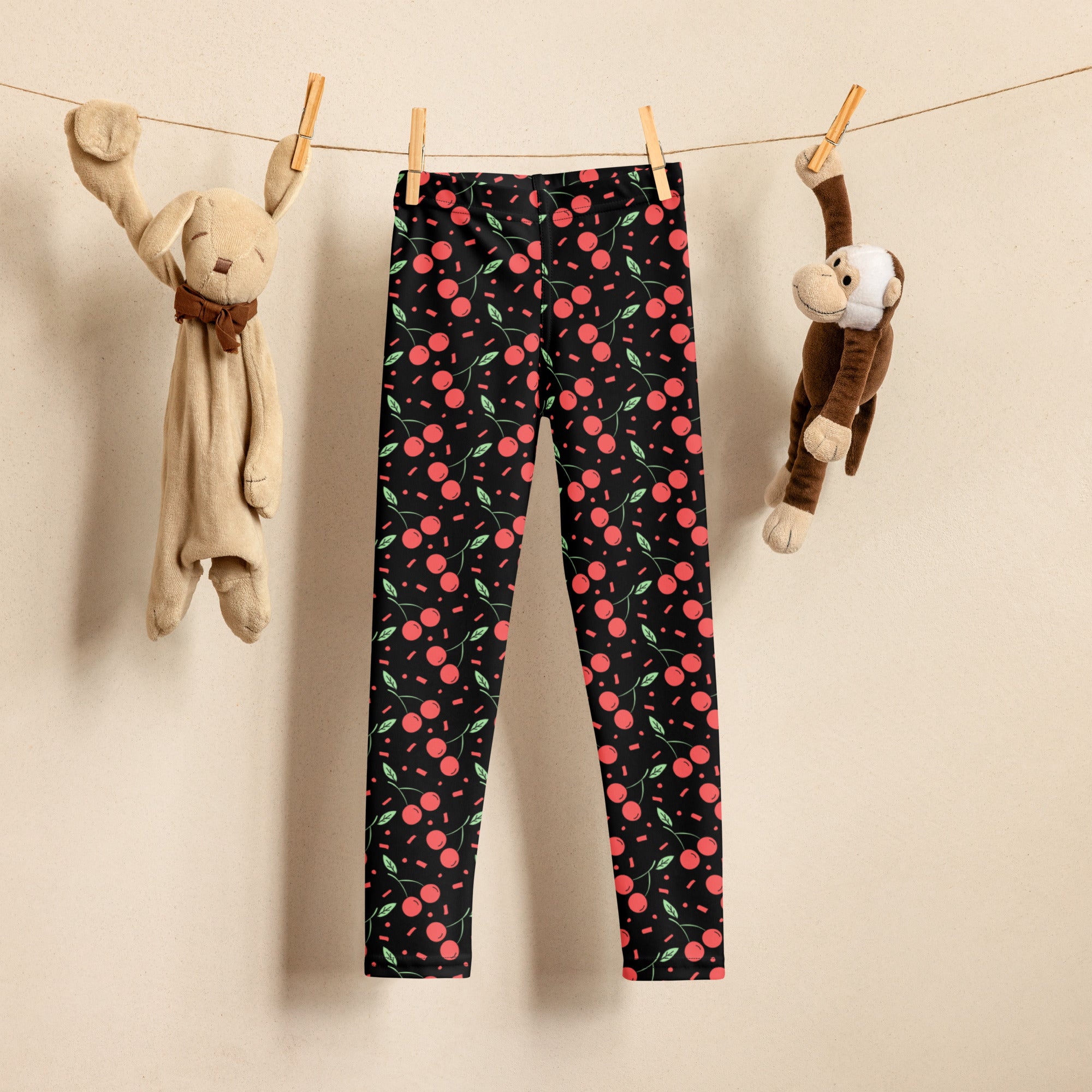 Girls black cherry confetti buttery soft leggings with vibrant pink cherry and green leaf pattern on black fabric