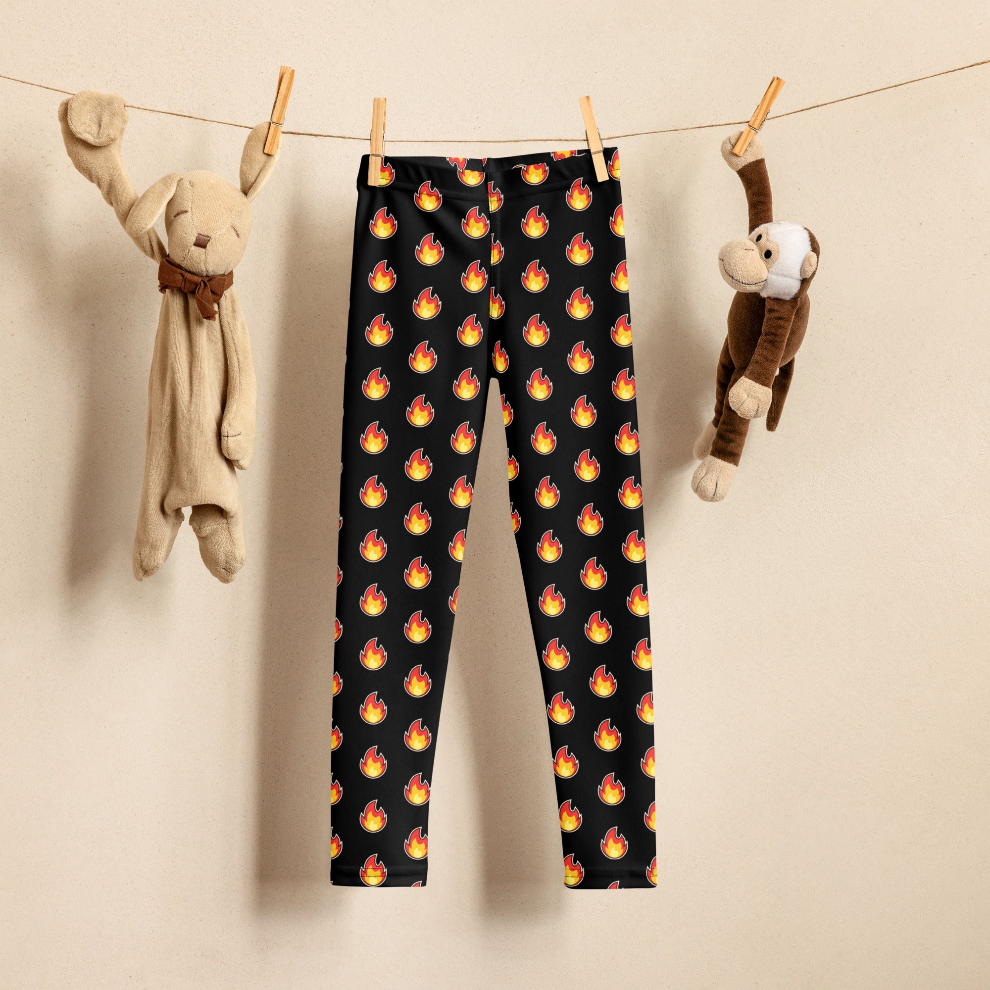 Black kids leggings with a buttery soft fabric featuring a repeating pattern of vibrant orange and yellow flames