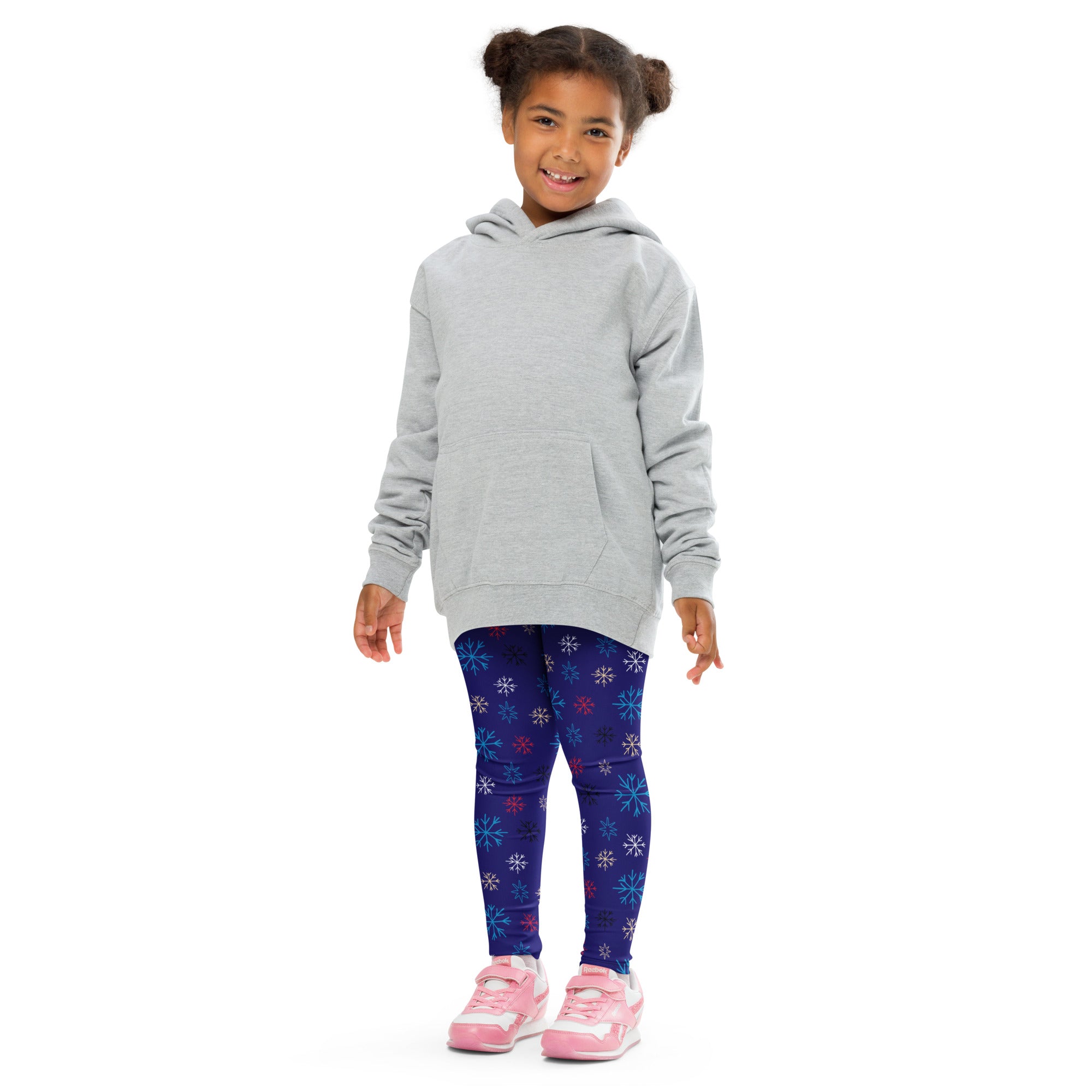 A child wearing kids snowflake pattern buttery soft dark blue leggings with colorful snowflakes and a light gray hooded sweatshirt