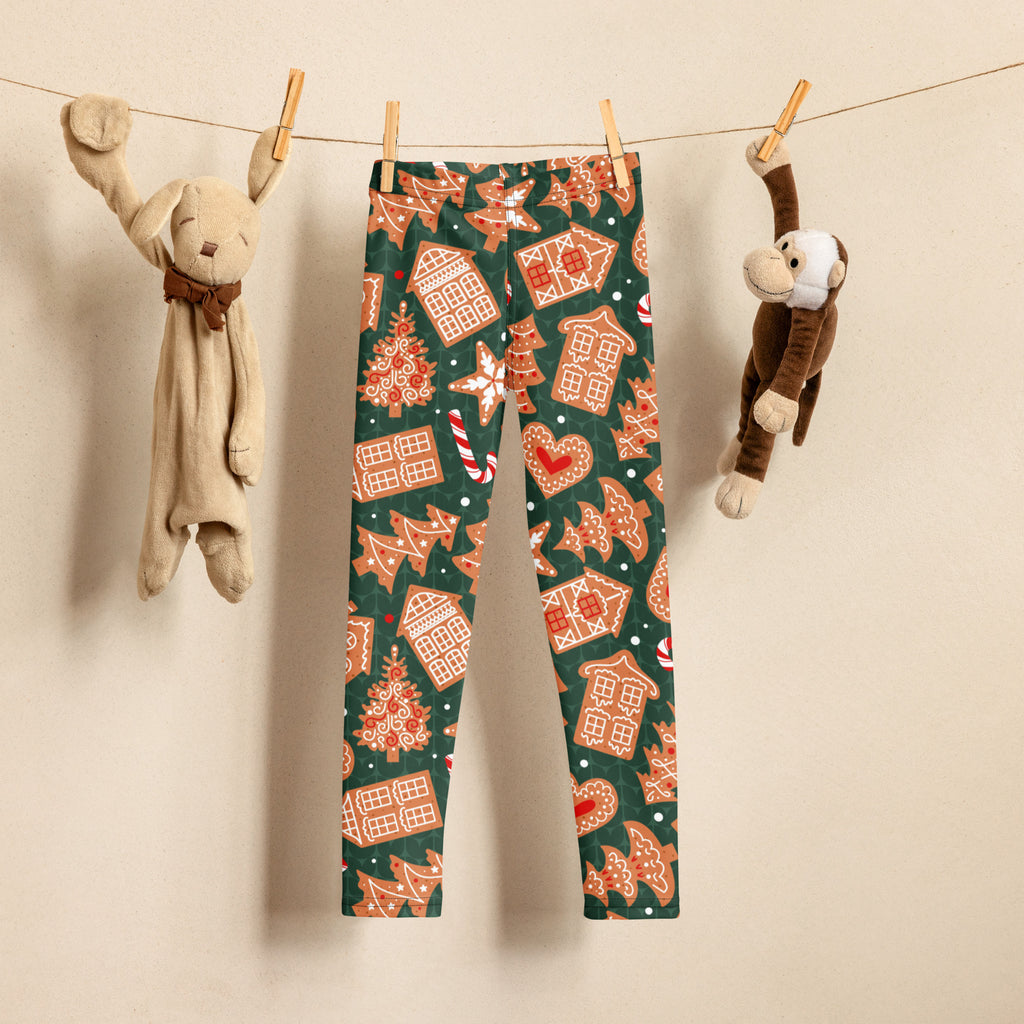 Kids green buttery soft leggings with festive orange and white gingerbread house tree and candy cane pattern