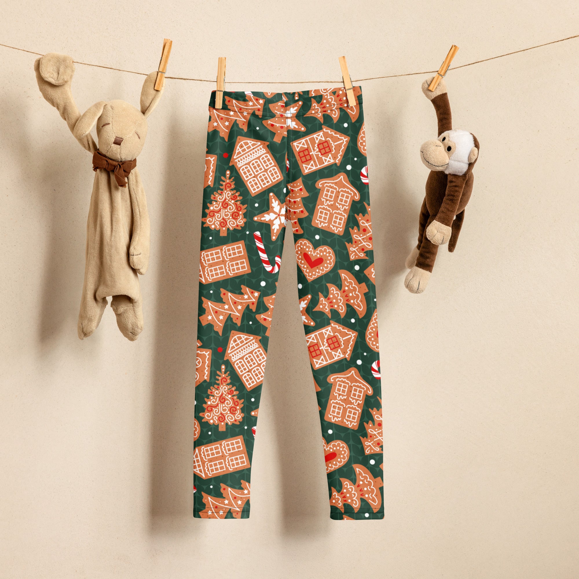 Kids green buttery soft leggings with festive orange and white gingerbread house tree and candy cane pattern