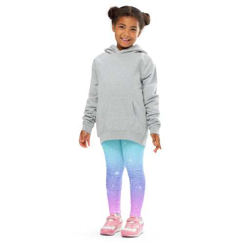 A young girl wearing girls faux sparkle effect rainbow buttery soft leggings in blue to purple gradient with stars