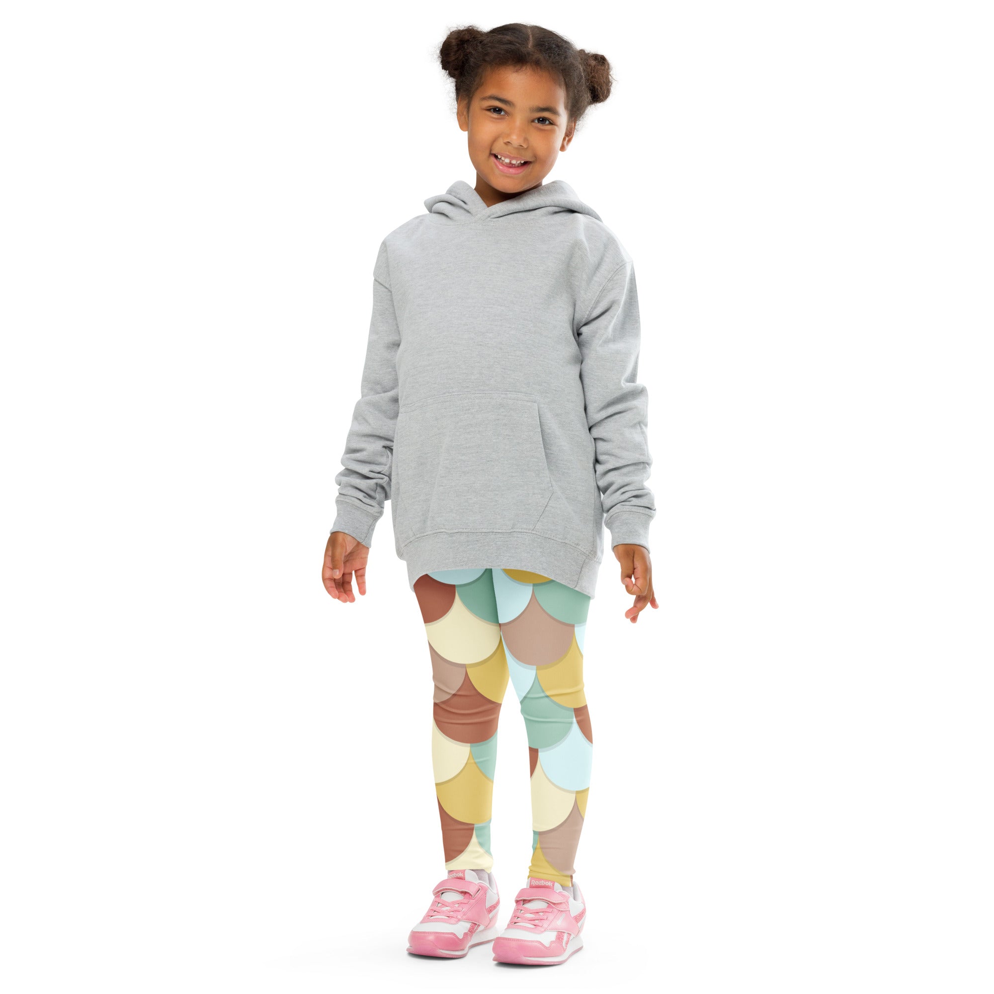 A child wearing buttery soft girls green and brown mermaid leggings with colorful pastel scale-patterns and a gray hoodie