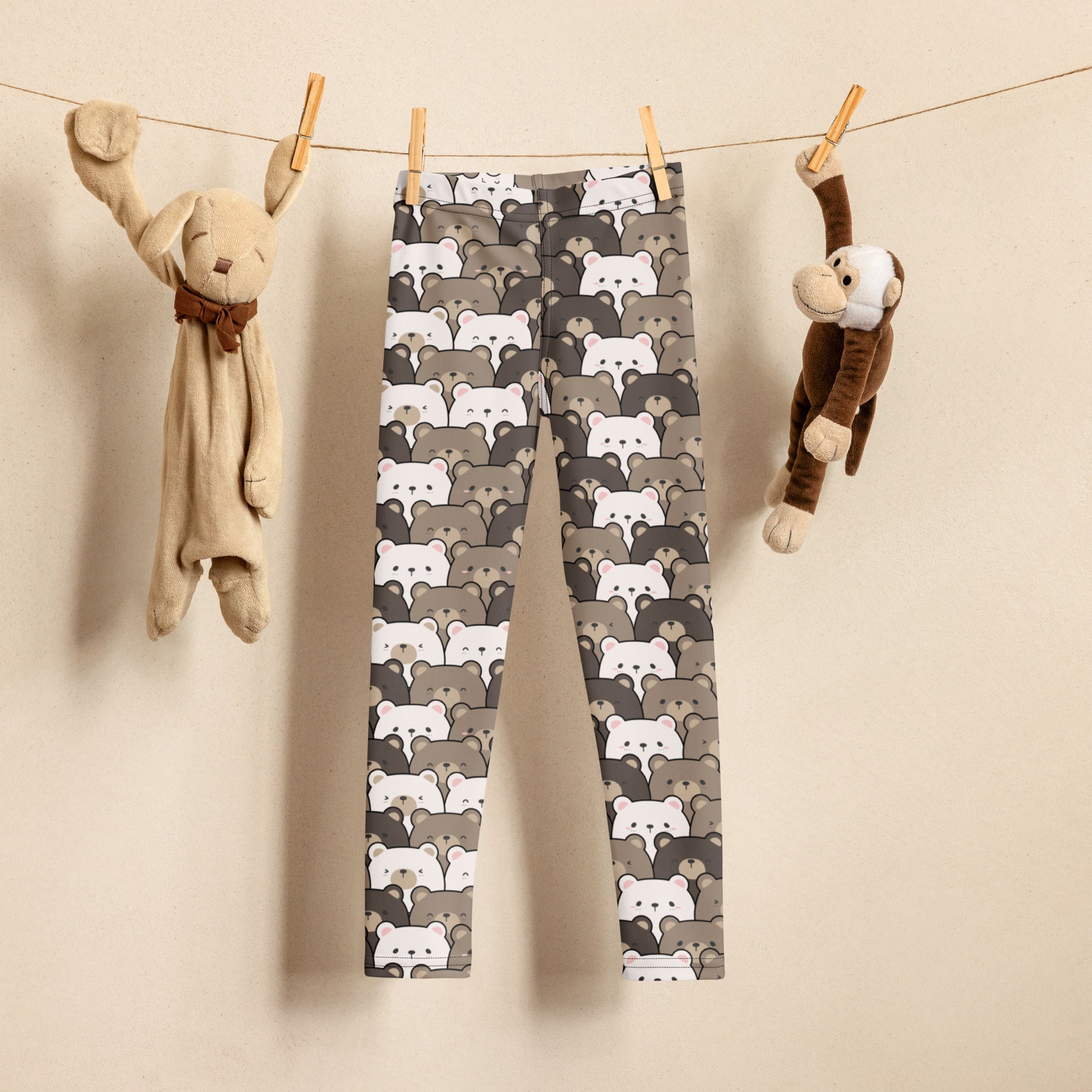 Kids brown bear print buttery soft gray and white bear-patterned leggings hanging on a clothesline
