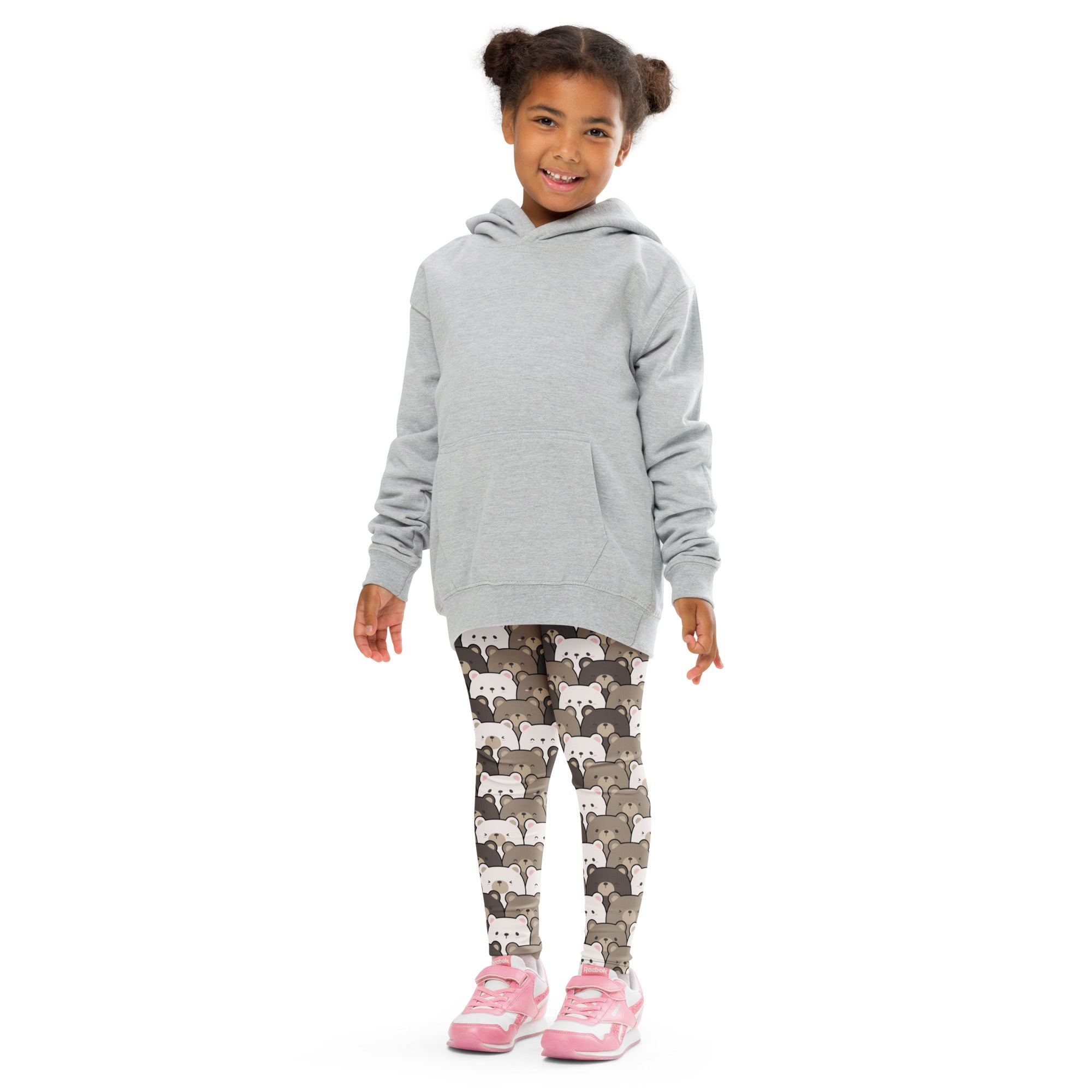 A child wearing kids brown bear print buttery soft leggings with cartoon raccoon patterns and a gray hooded sweatshirt