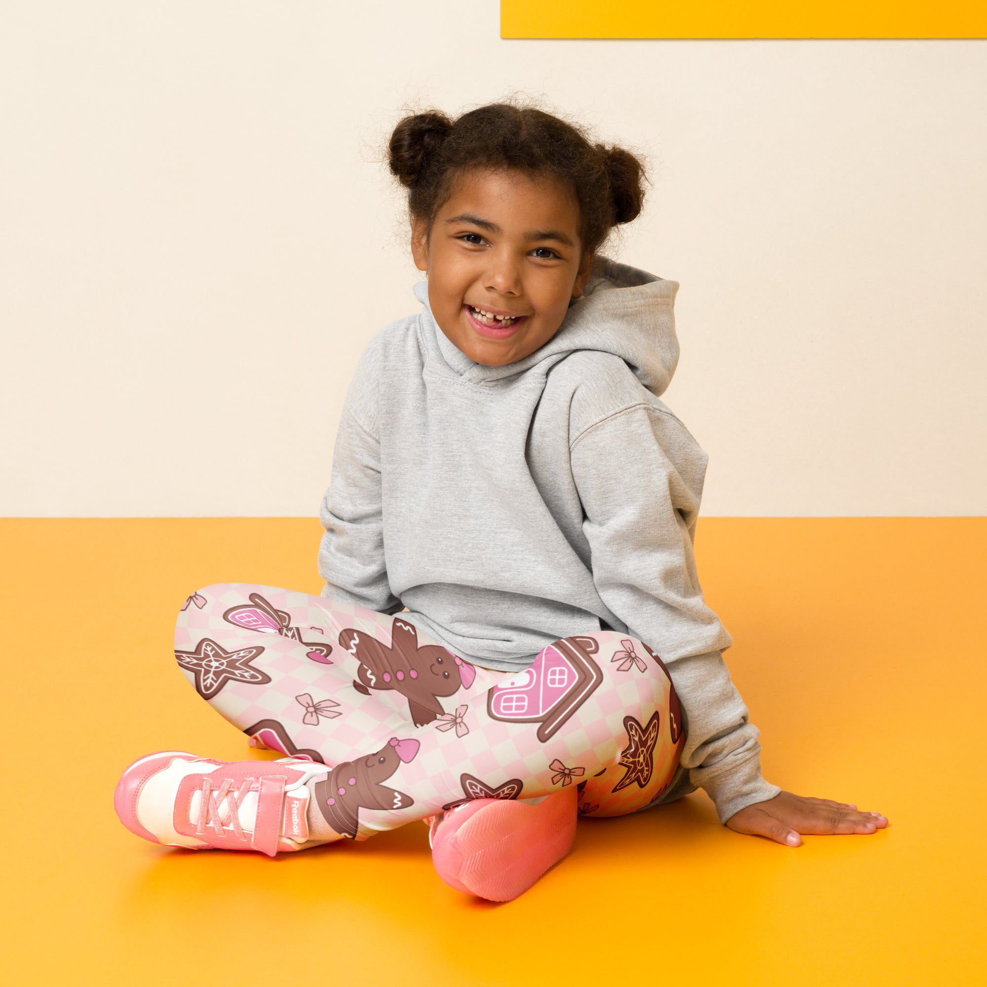 A child wearing girls pink gingerbread christmas buttery soft leggings with brown gingerbread and starfish patterns