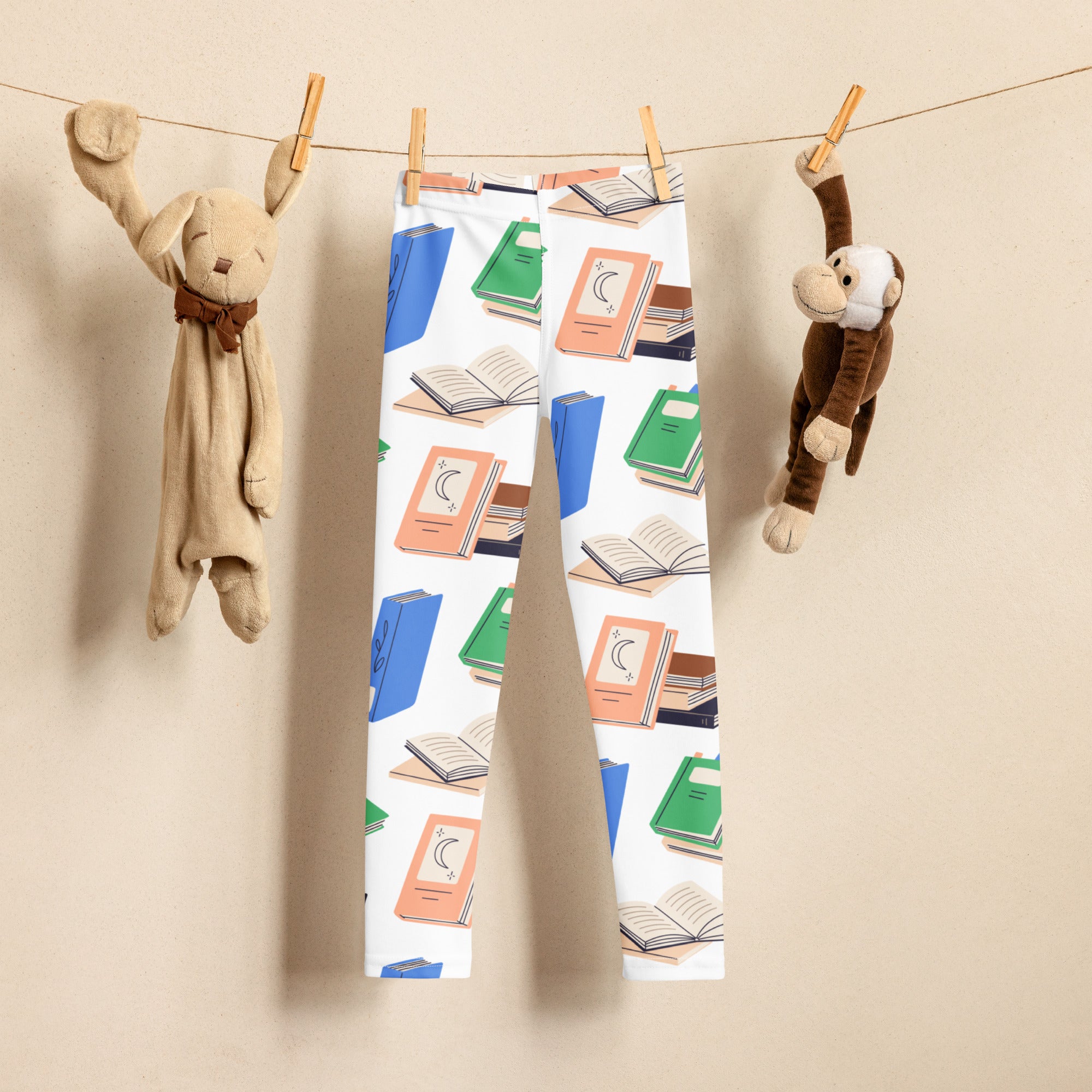 White kids leggings with a playful blue green and orange book pattern made from buttery soft fabric