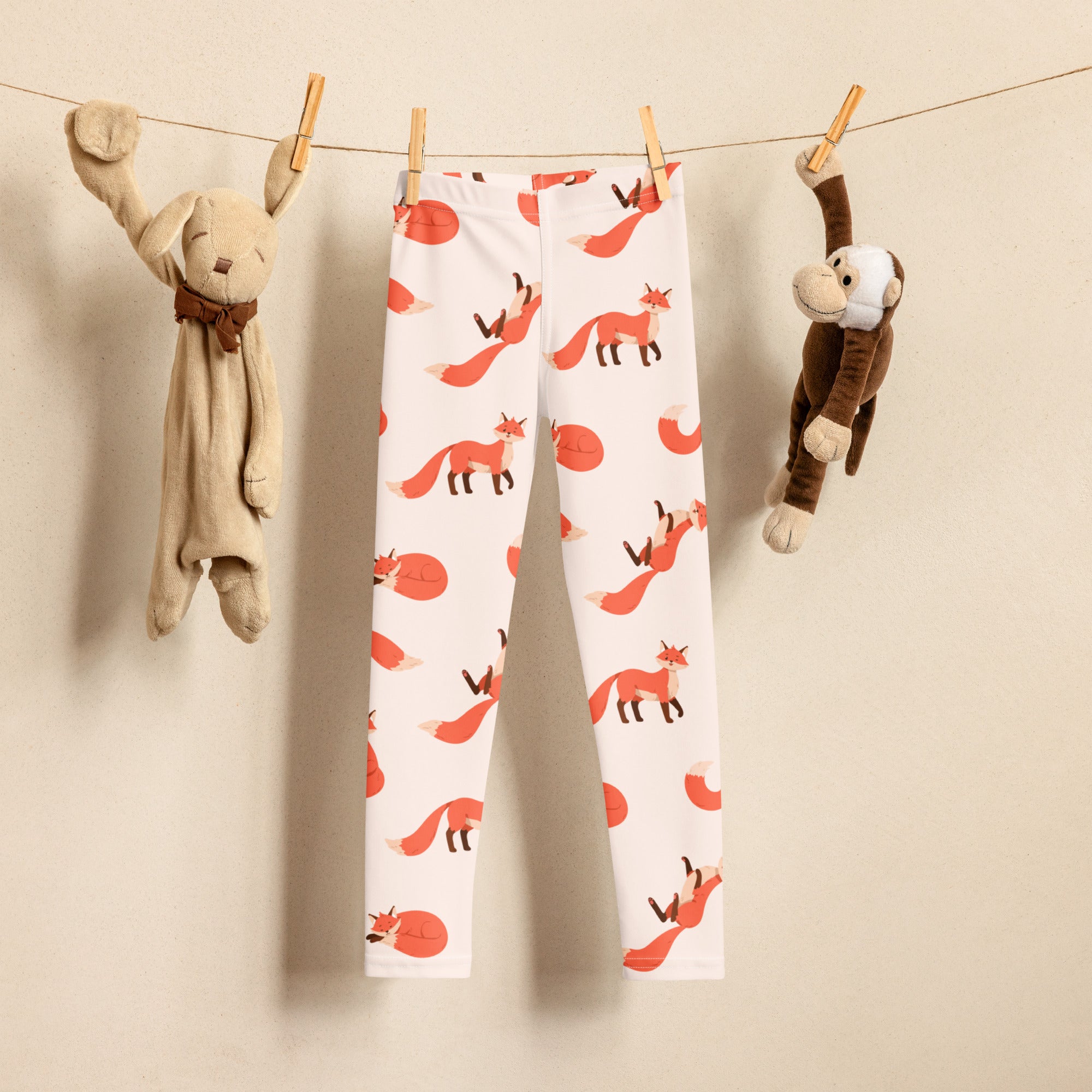 White kids leggings with a playful orange fox and red circle pattern made from buttery soft fabric