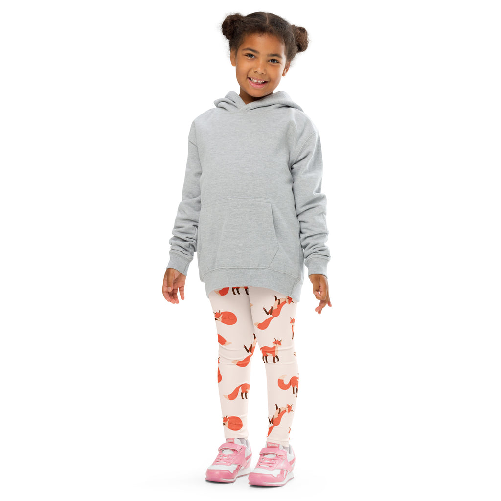 A child wearing kids fox print buttery soft white leggings with orange foxes and a light gray hooded sweatshirt
