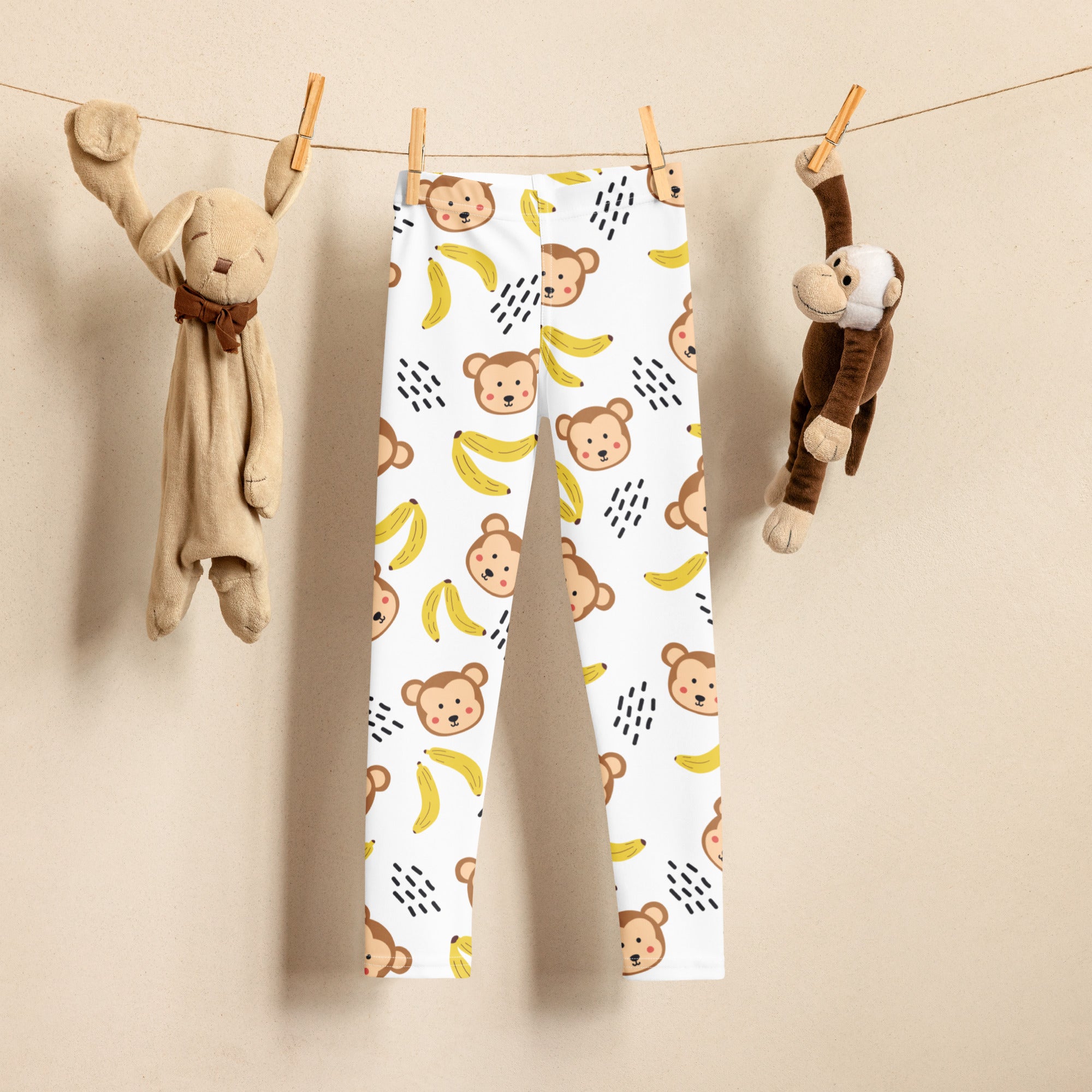 White kids monkey and banana buttery soft leggings with playful brown monkey faces and yellow banana pattern