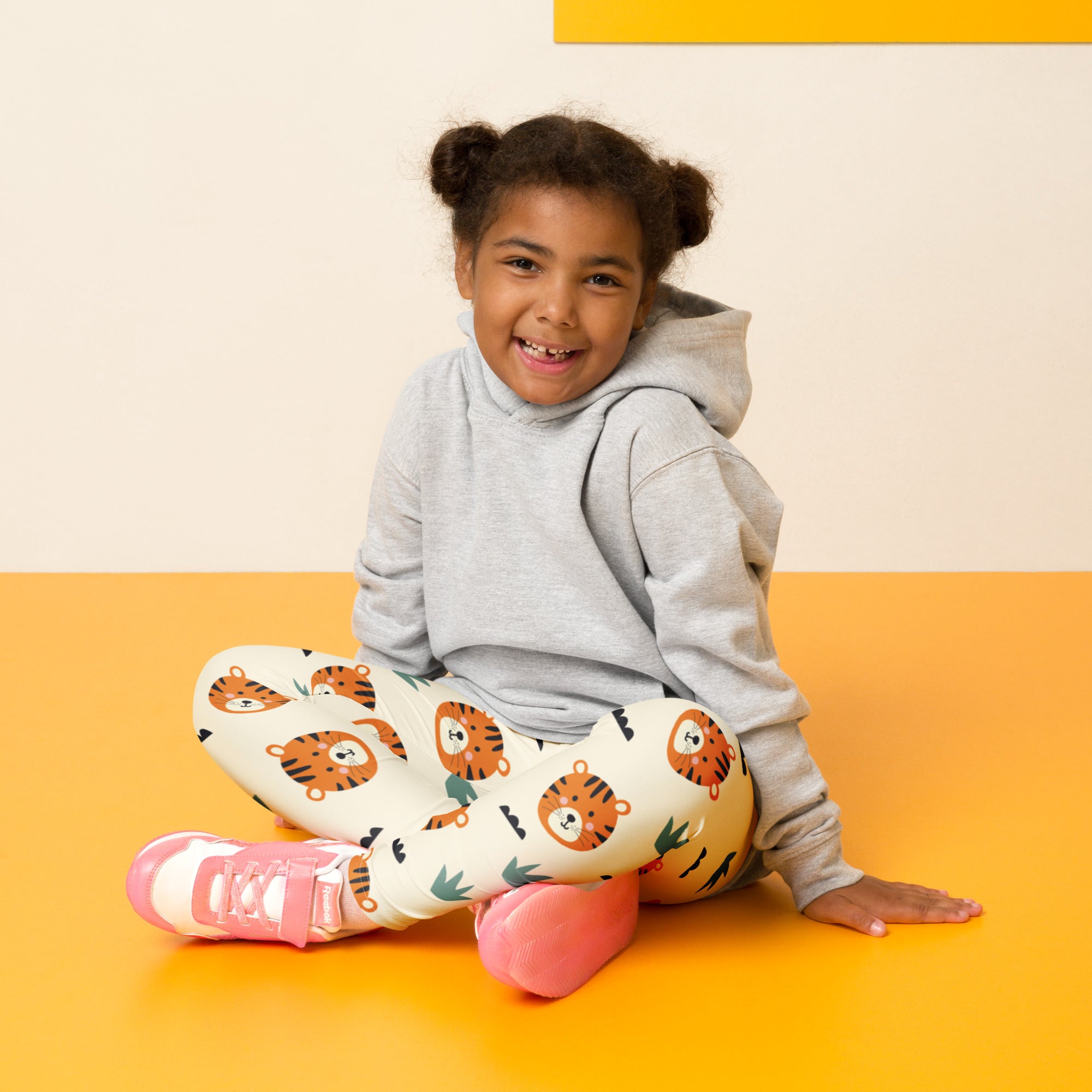 Kids tiger print buttery soft leggings in white with orange and black tiger faces and green palm leaves pattern