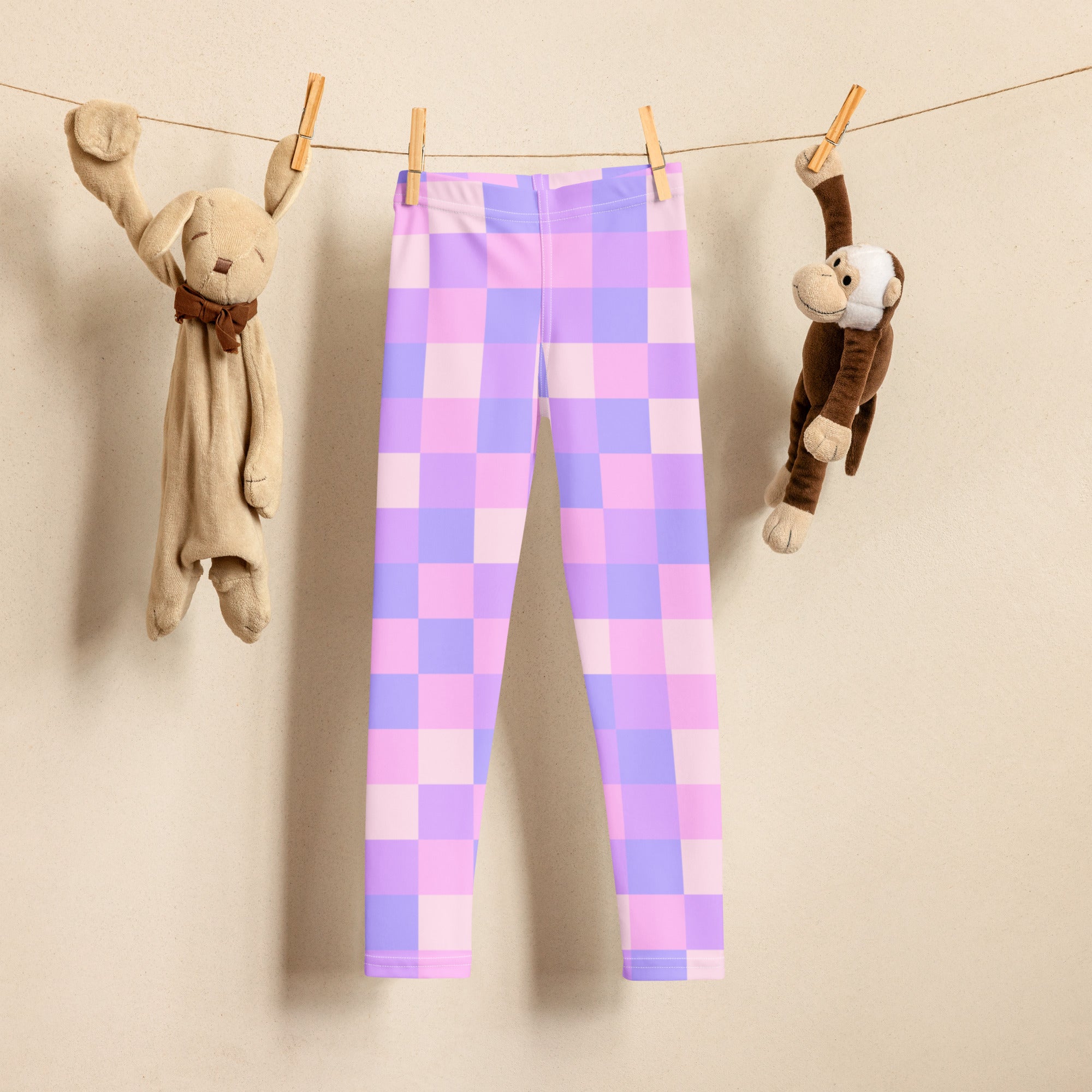 Girls purple checkered buttery soft leggings in pastel purple and lavender hanging on a clothesline