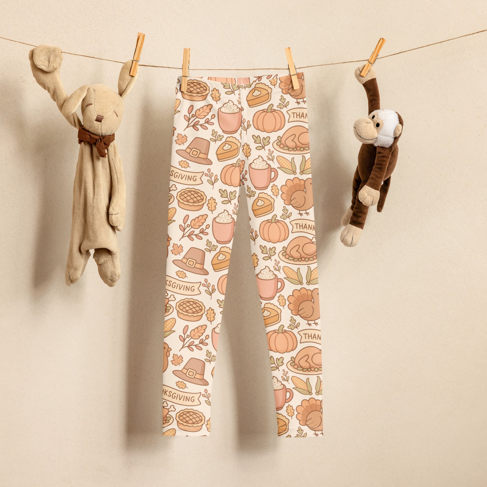 Kids thanksgiving buttery soft leggings with cream base and orange brown pink pumpkins pies turkeys hats and leaves illustrations