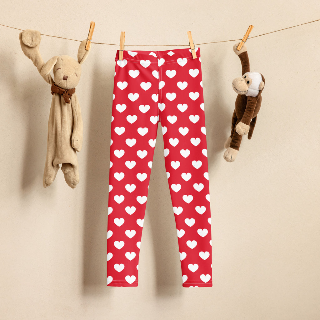 Girls red heart buttery soft leggings with white heart pattern hanging on a clothesline