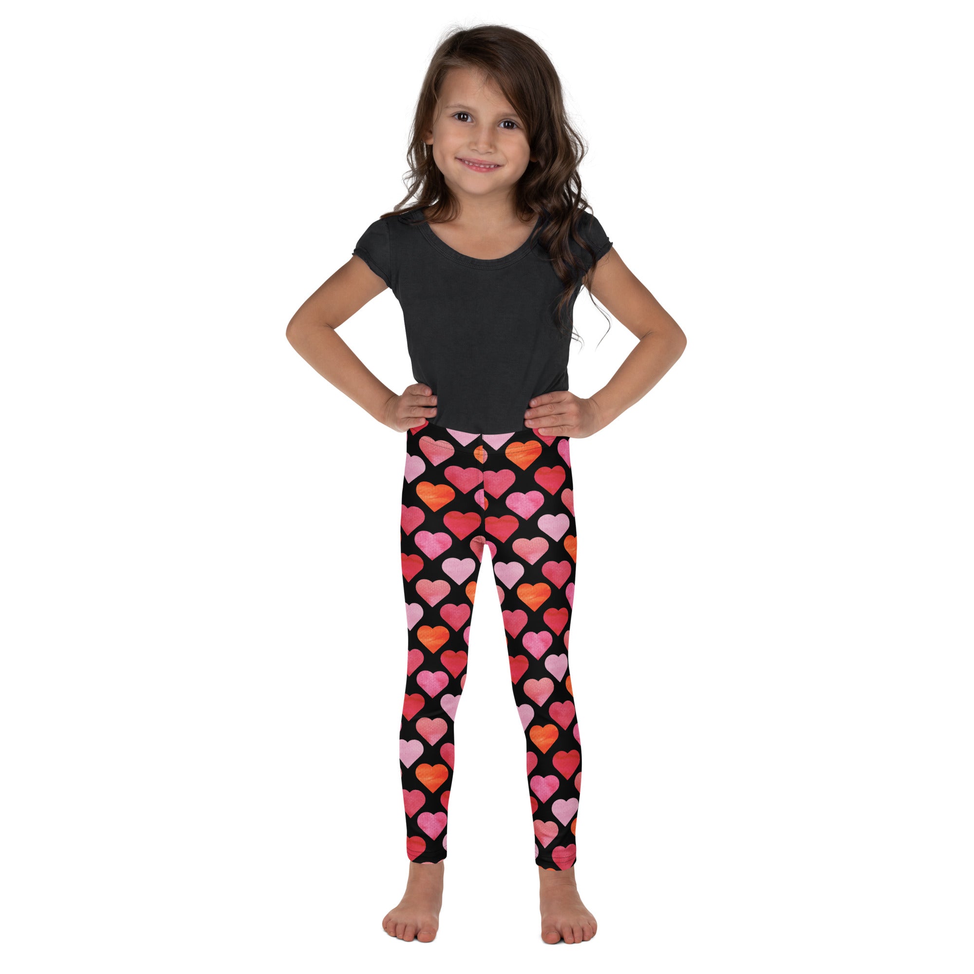 Girls black heart buttery soft leggings featuring vibrant pink and orange heart patterns on soft fabric