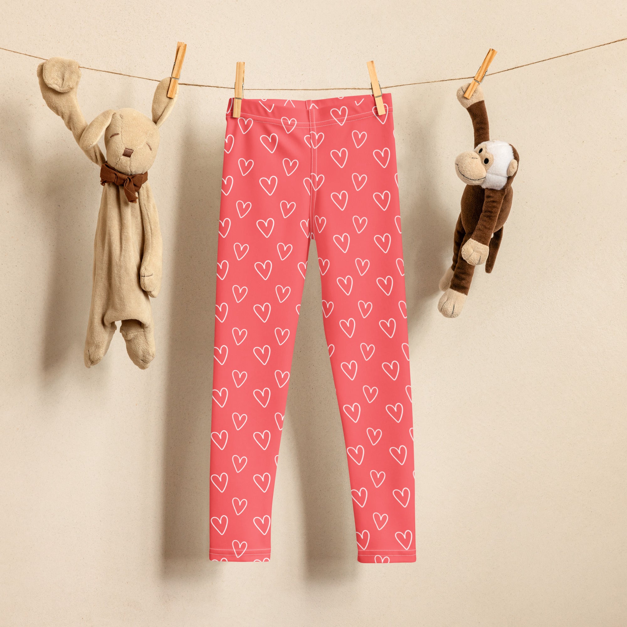 Girls pink heart outline buttery soft leggings hanging on a clothesline showing the front side