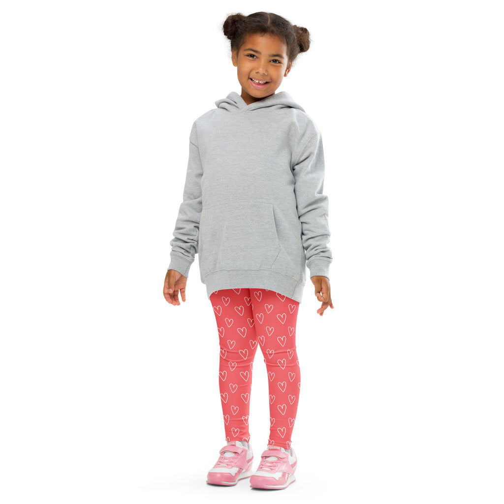 Girl wearing pink heart outline buttery soft leggings paired with a gray hooded sweatshirt with front pocket