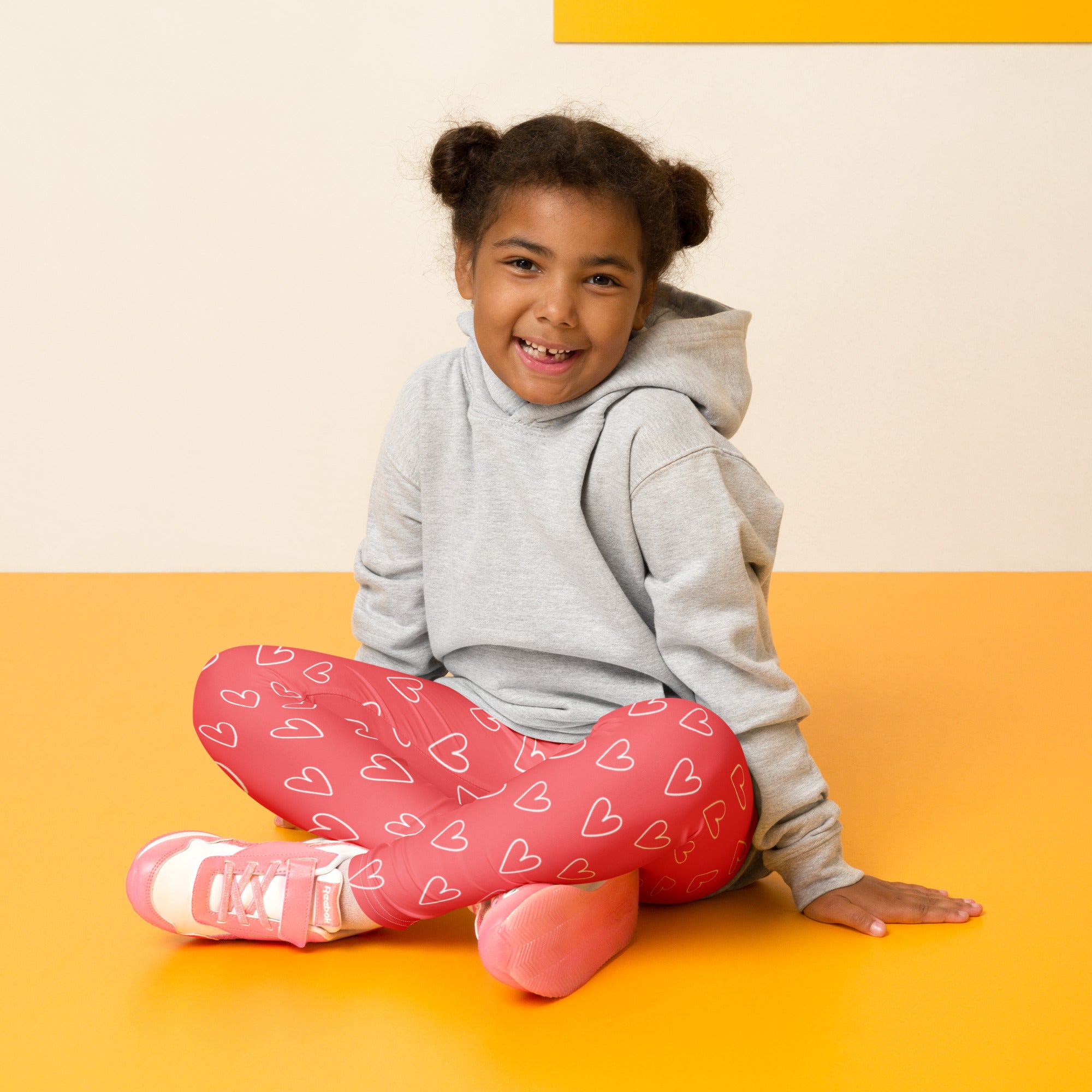 Girls pink heart outline buttery soft leggings featuring white heart patterns and a stretchy comfortable fit