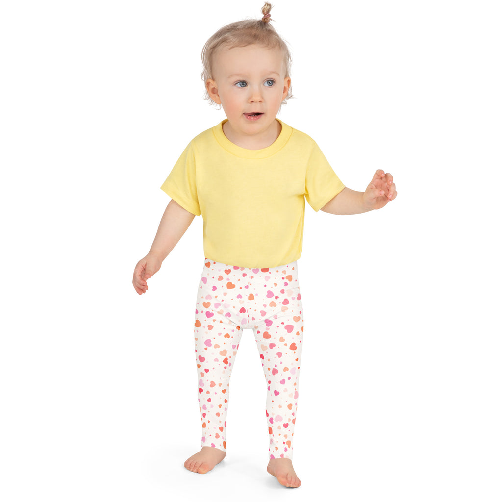 Yellow short-sleeved t-shirt paired with pastel heart buttery soft white leggings for girls with pink and orange hearts