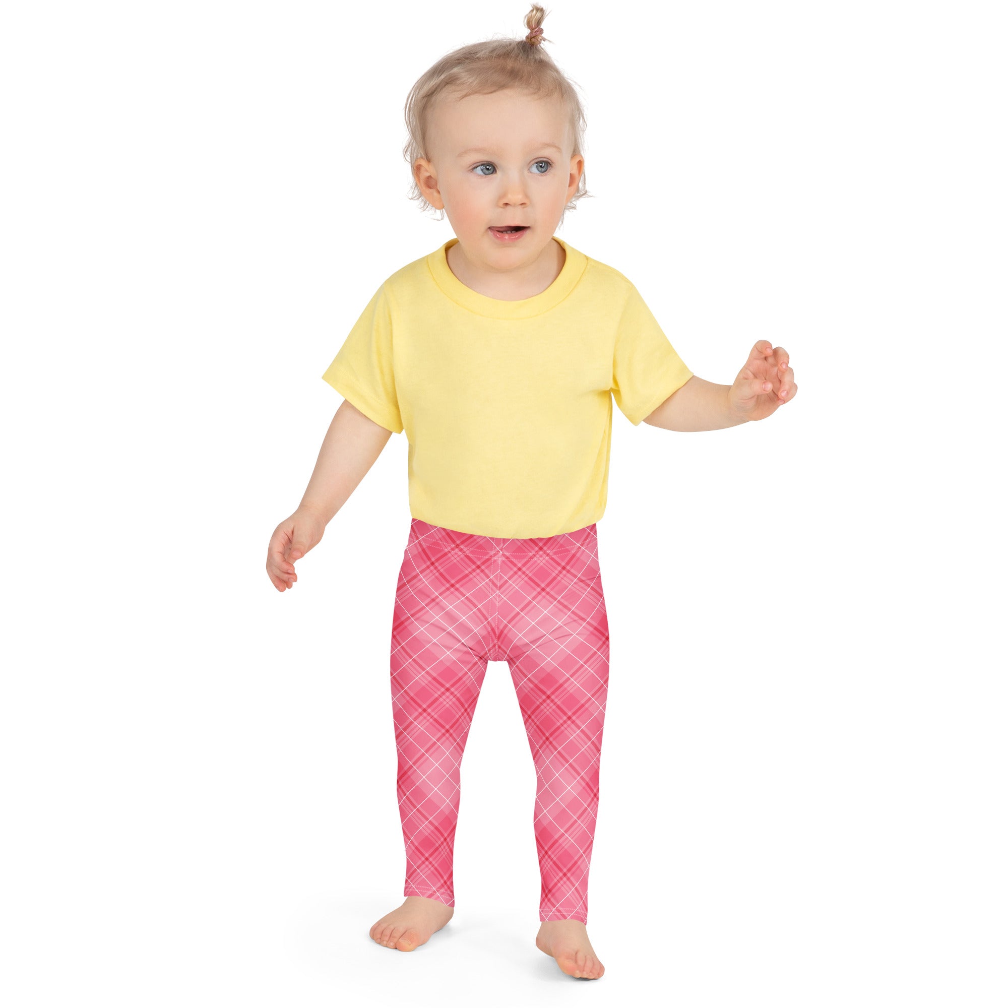 A toddler wearing girls pink plaid buttery soft leggings and a yellow short-sleeved shirt