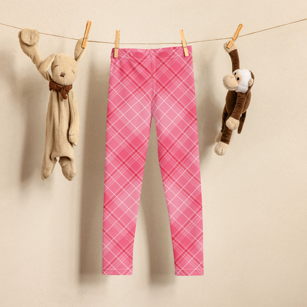 Girls pink plaid buttery soft leggings hanging on a clothesline showcasing the colorful pattern and soft fabric