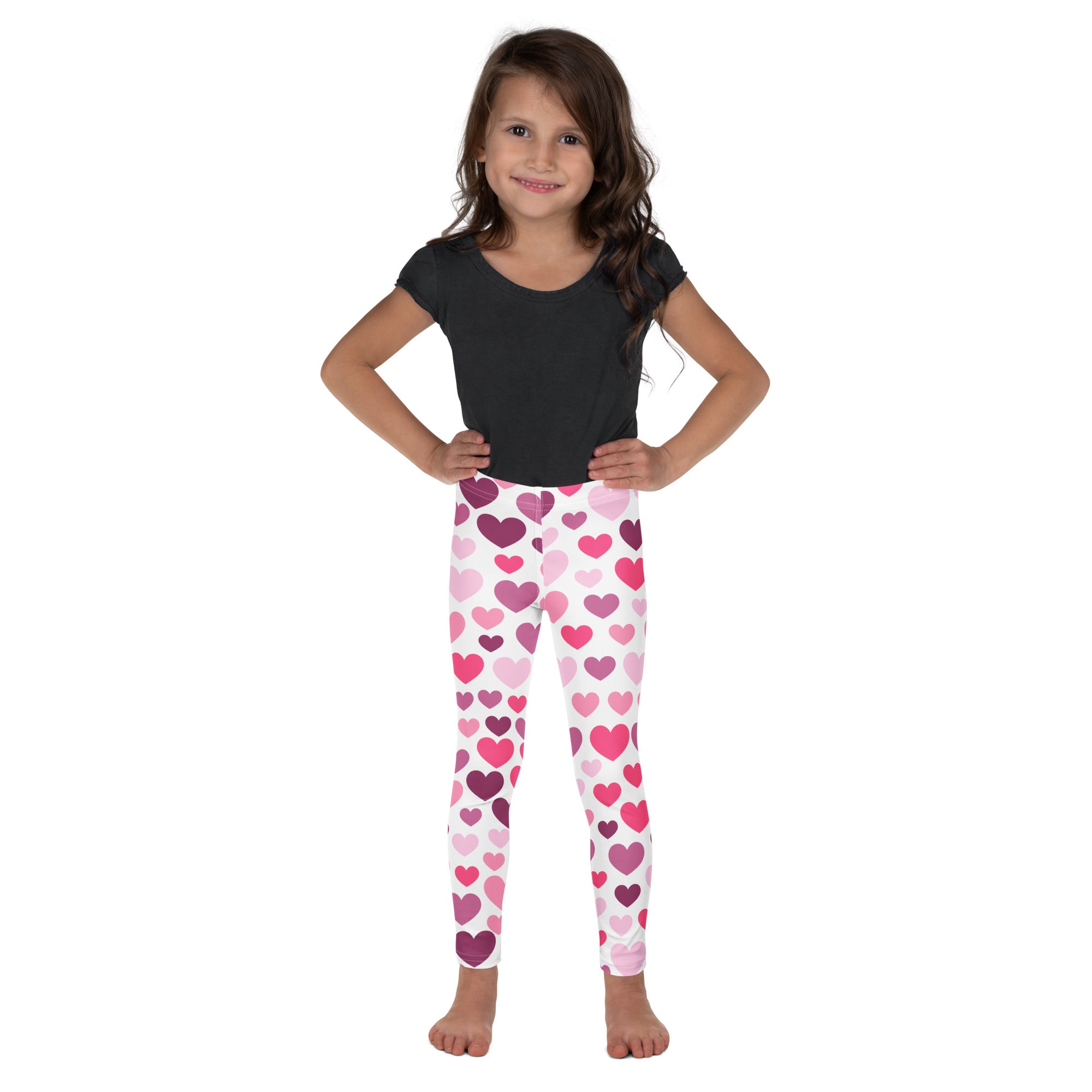 Girls purple and pink hearts buttery soft leggings worn by a young girl featuring heart pattern in purple and pink
