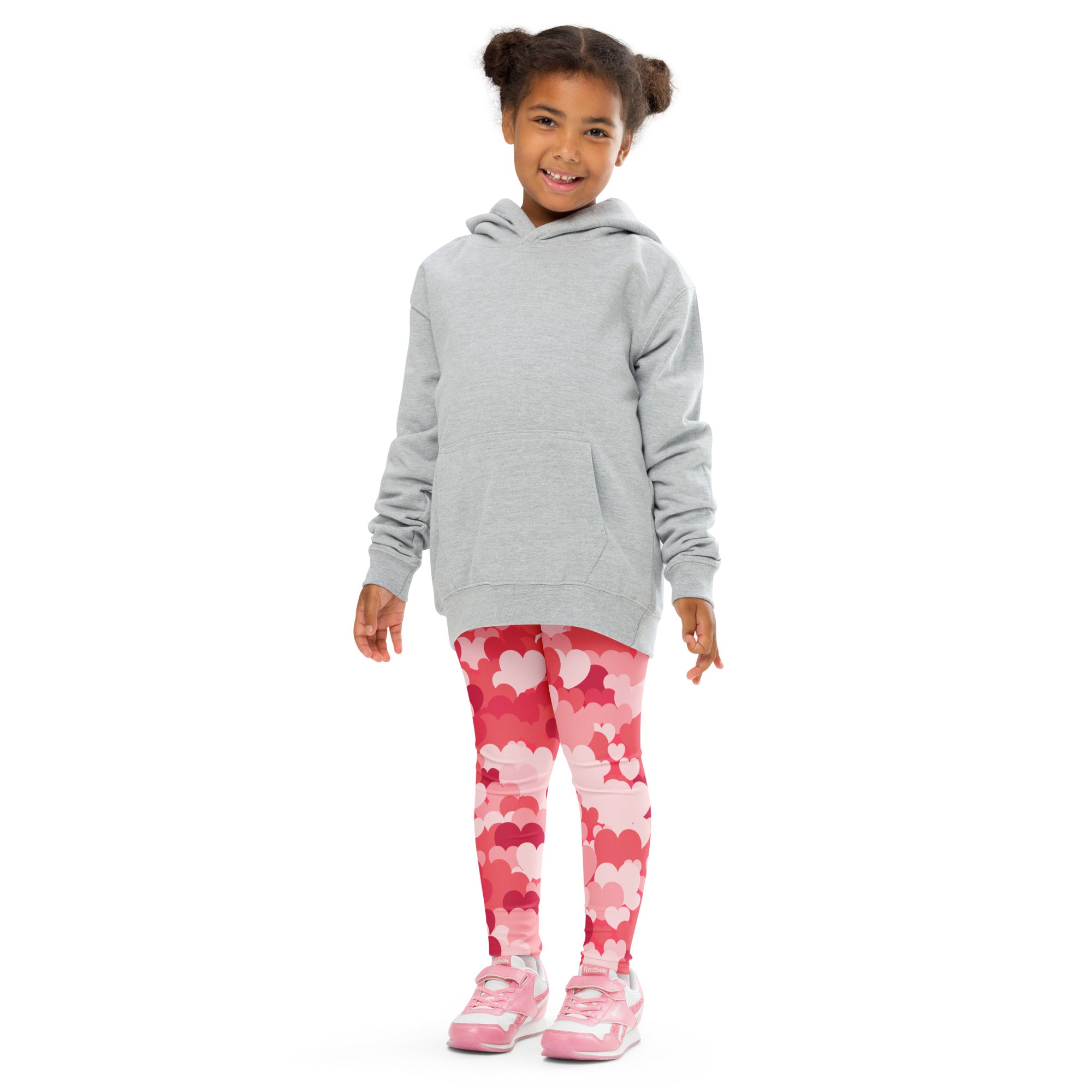 A child wearing girls pink heart cloud buttery soft leggings in pink with a light gray hooded sweatshirt and pink sneakers