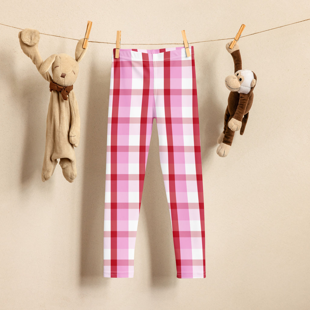 Girls pink and red plaid buttery soft leggings hanging on clothesline showing pink and white pattern