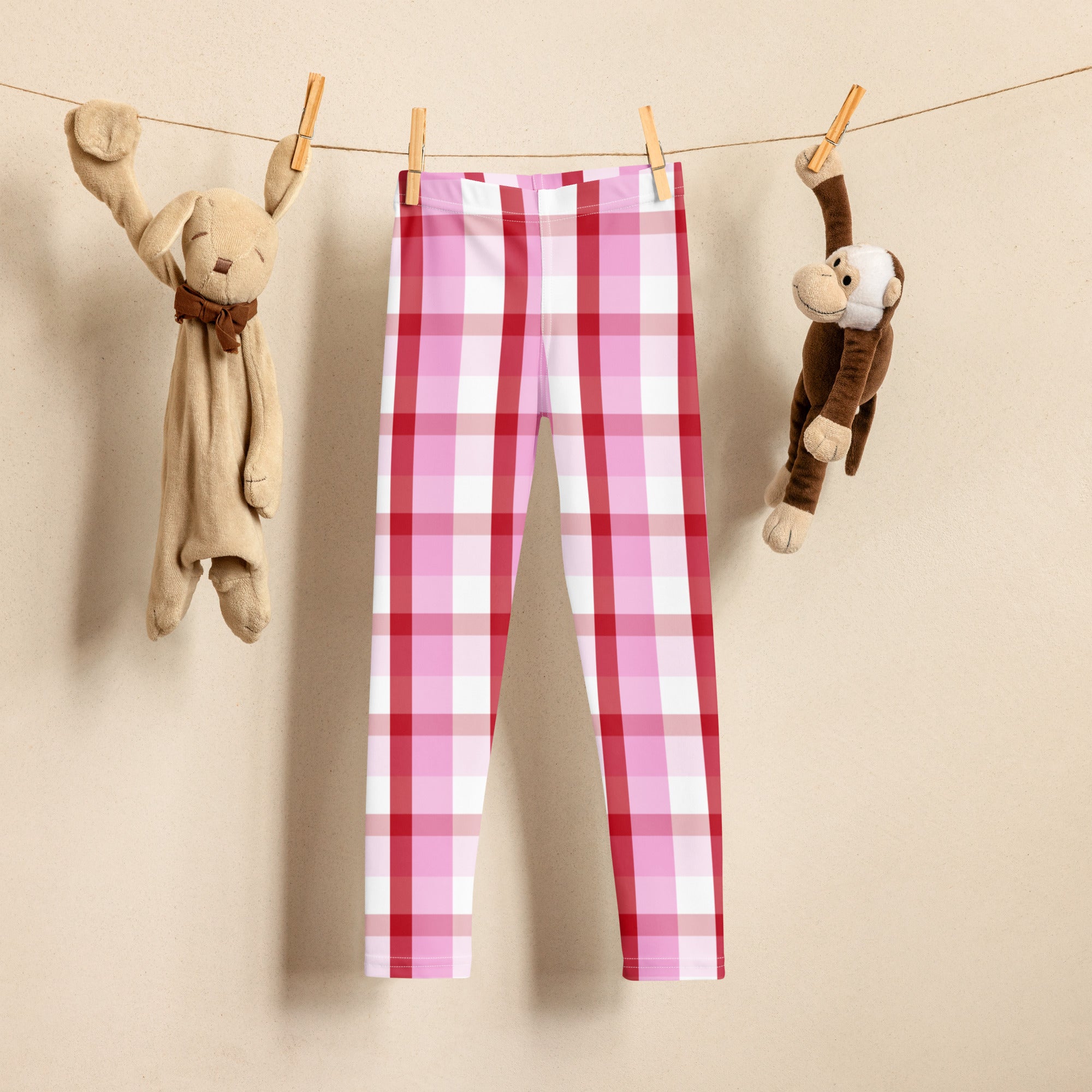 Girls pink and red plaid buttery soft leggings hanging on clothesline showing pink and white pattern