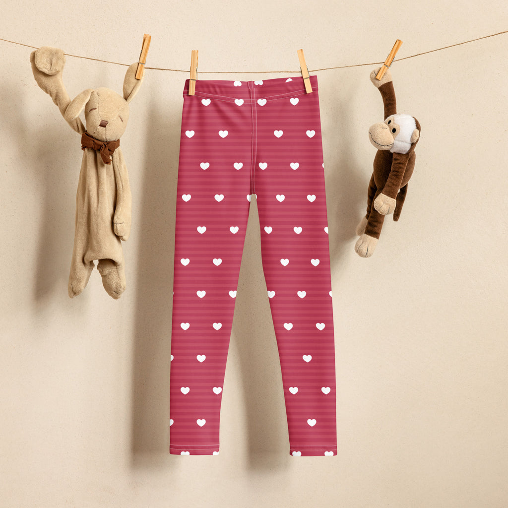 Girls pink stripe heart leggings buttery soft fabric with white heart patterns and subtle horizontal stripes hanging