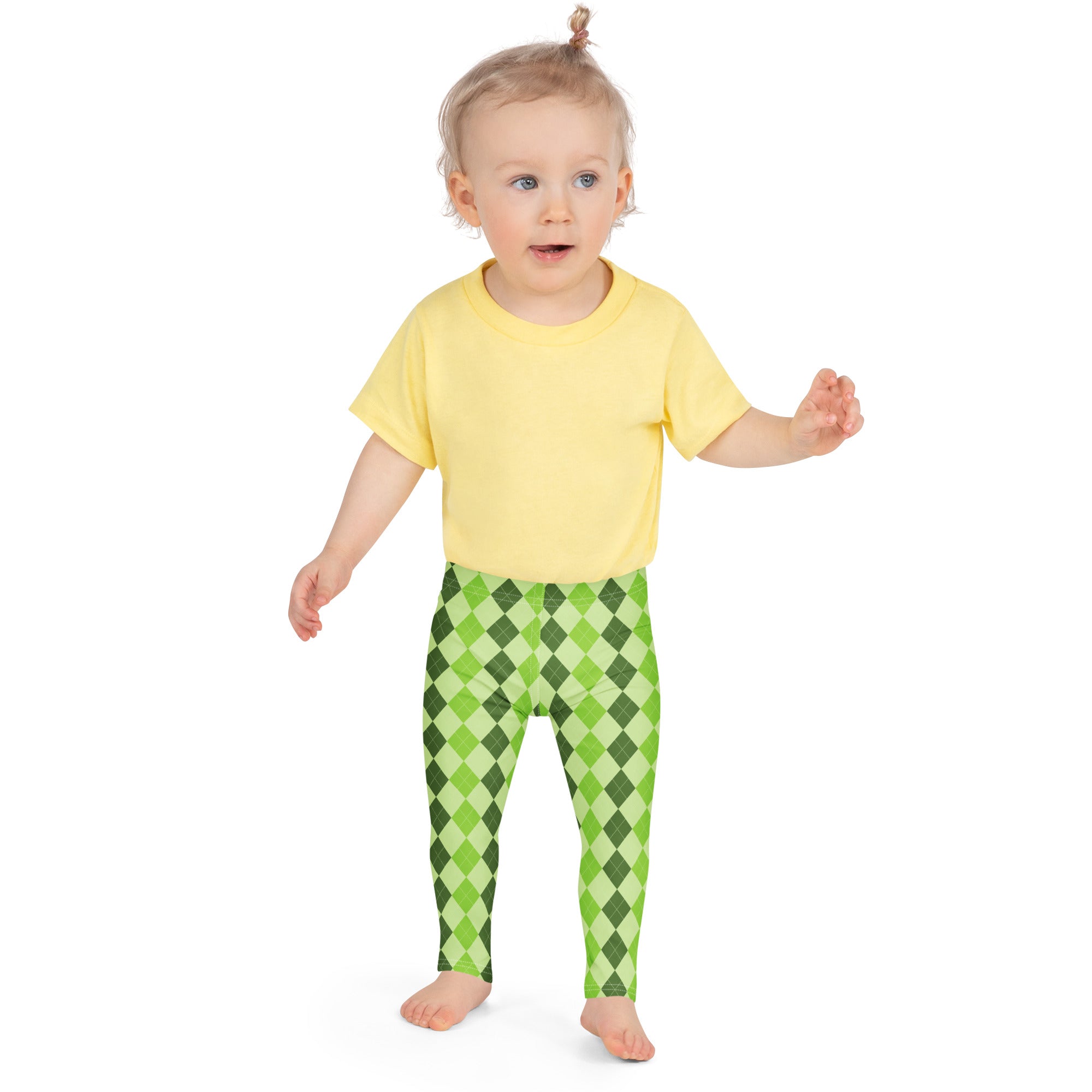 A toddler wearing girls light green argyle buttery soft leggings and a yellow short-sleeved shirt