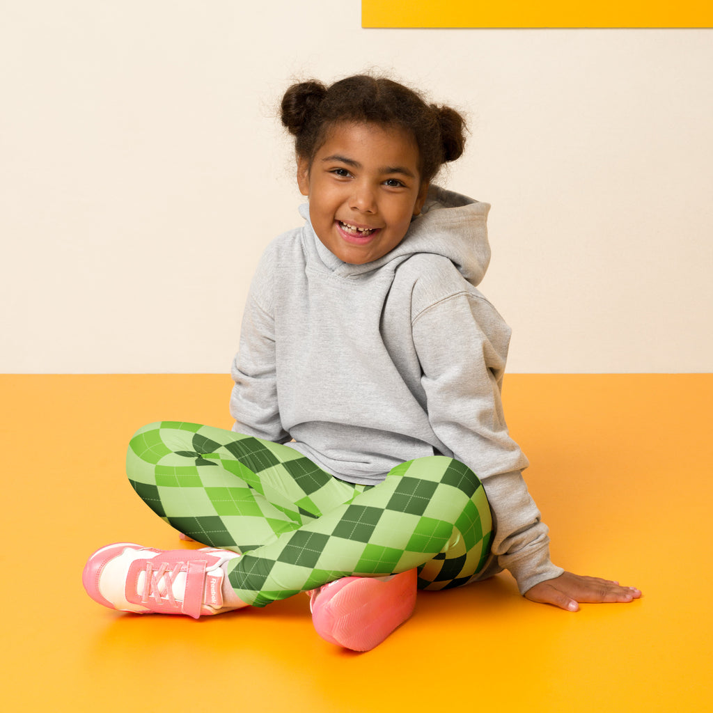 A child wearing girls light green argyle buttery soft leggings made of soft fabric paired with a gray hoodie