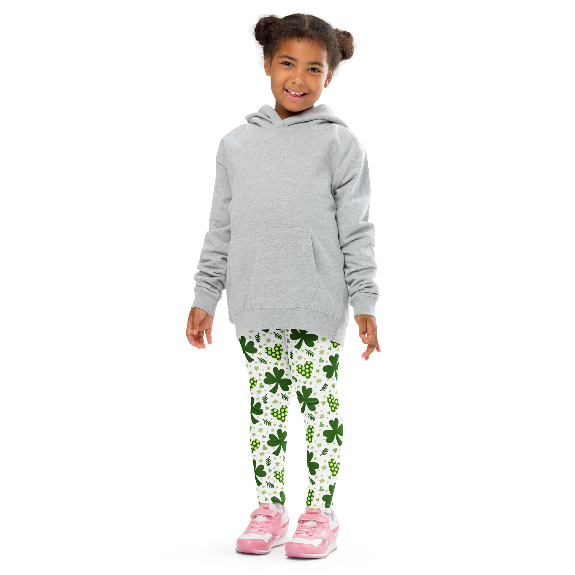 A child wearing girls shamrock and heart buttery soft white leggings with green shamrock patterns and gray hoodie