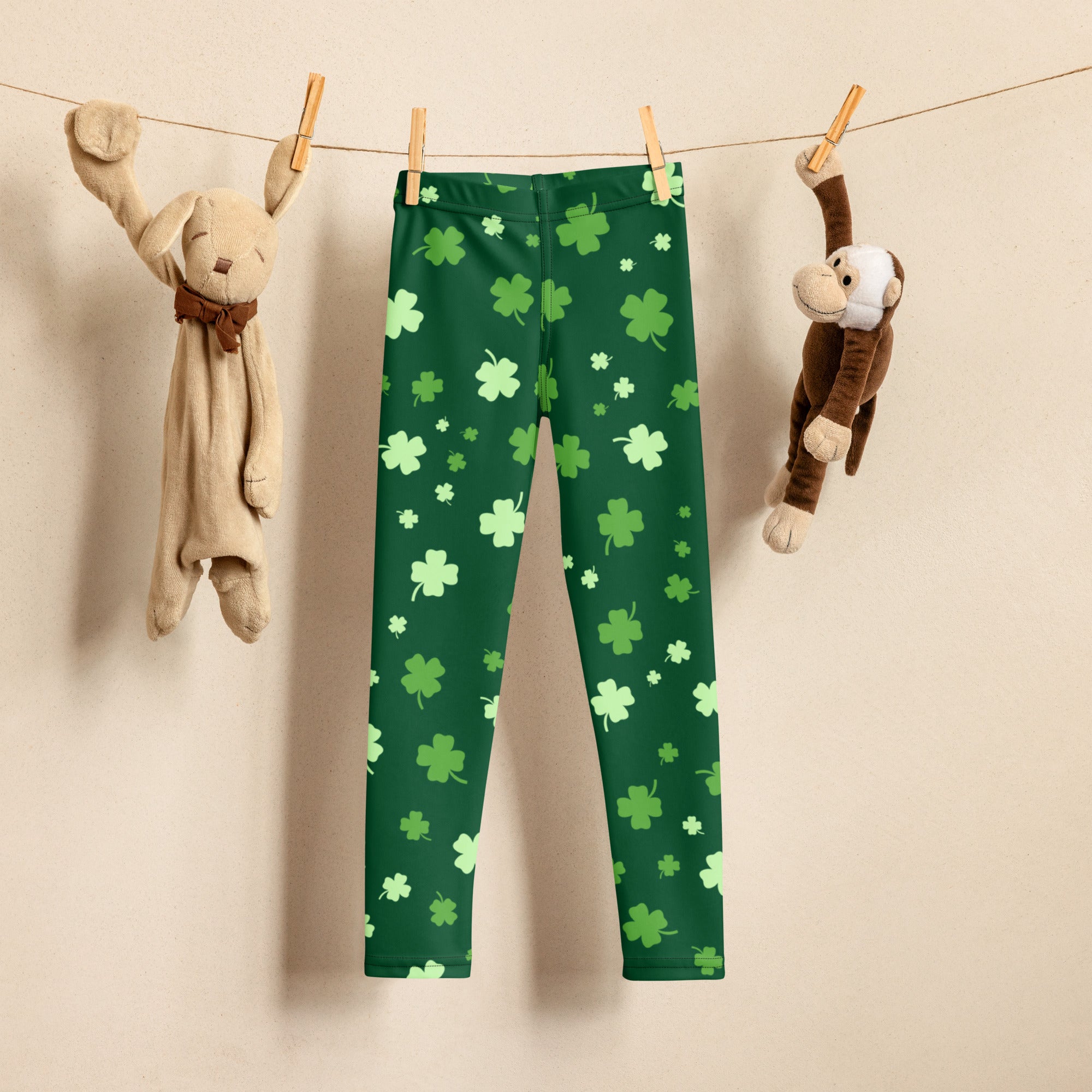 Green buttery soft girls leggings with light green and white shamrocks hanging on a clothesline for st patricks day