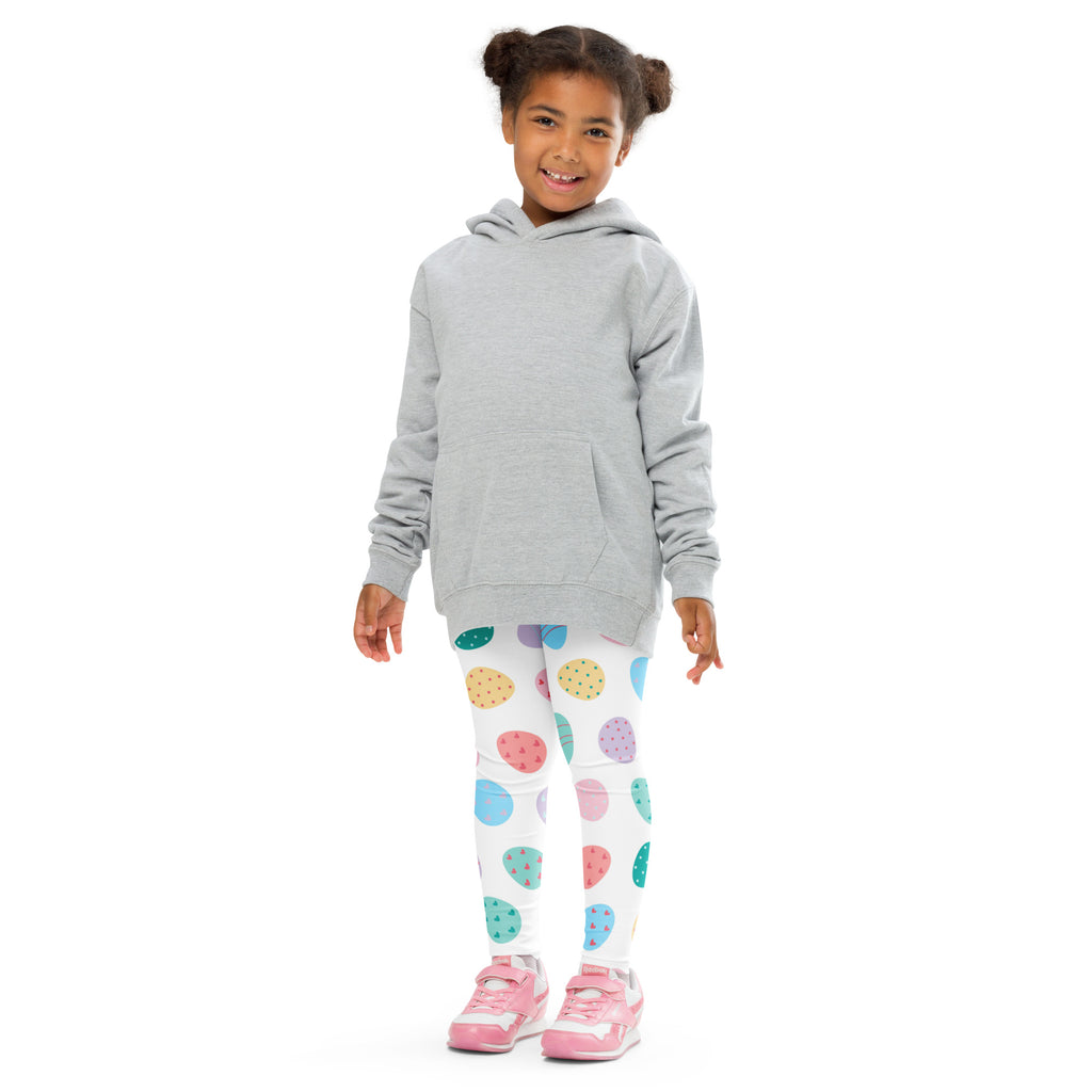 A child wearing girls pastel easter egg buttery soft leggings with colorful pastel polka dots and pink sneakers