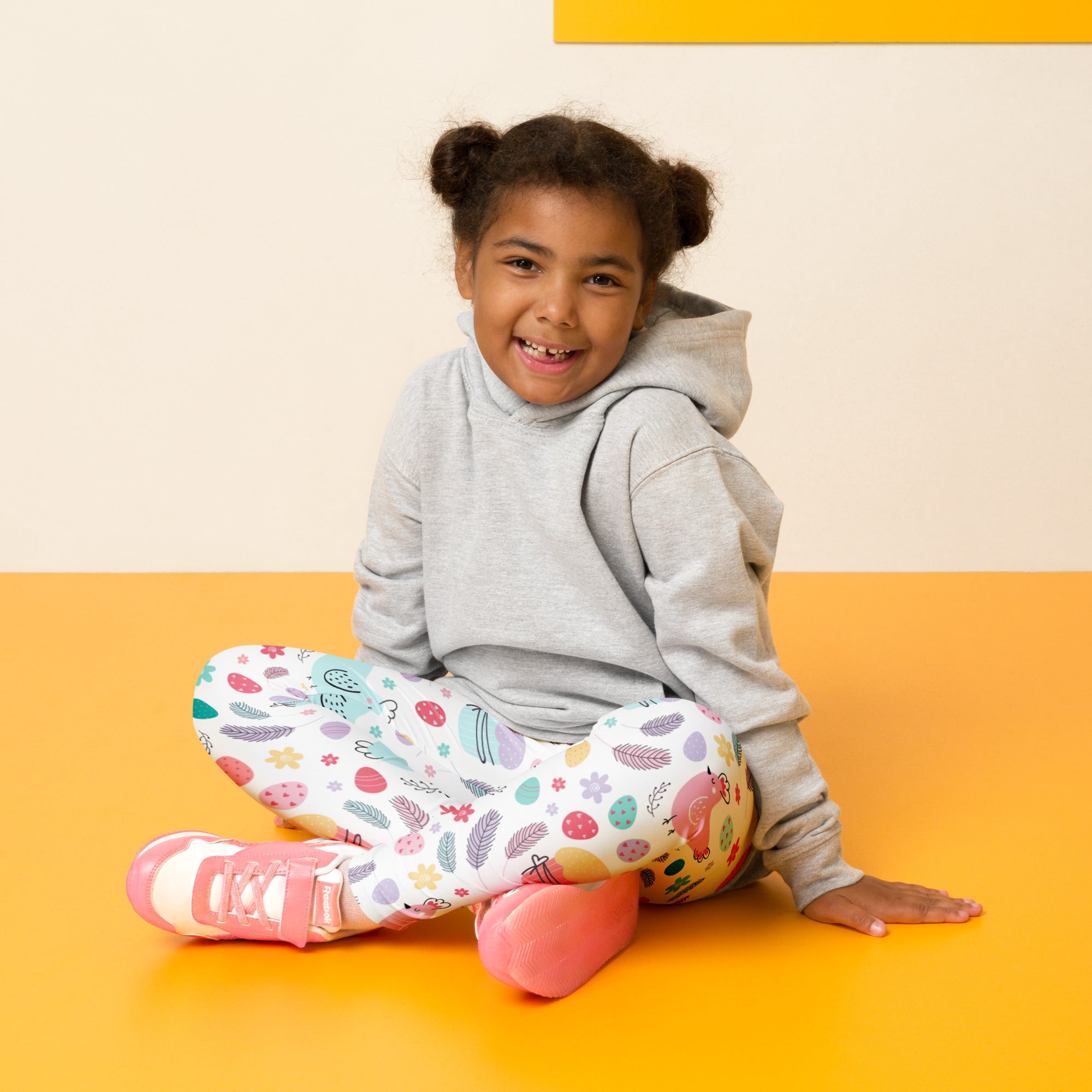 A child wearing girls Easter bunny and chick buttery soft leggings with pastel floral feather and fruit patterns
