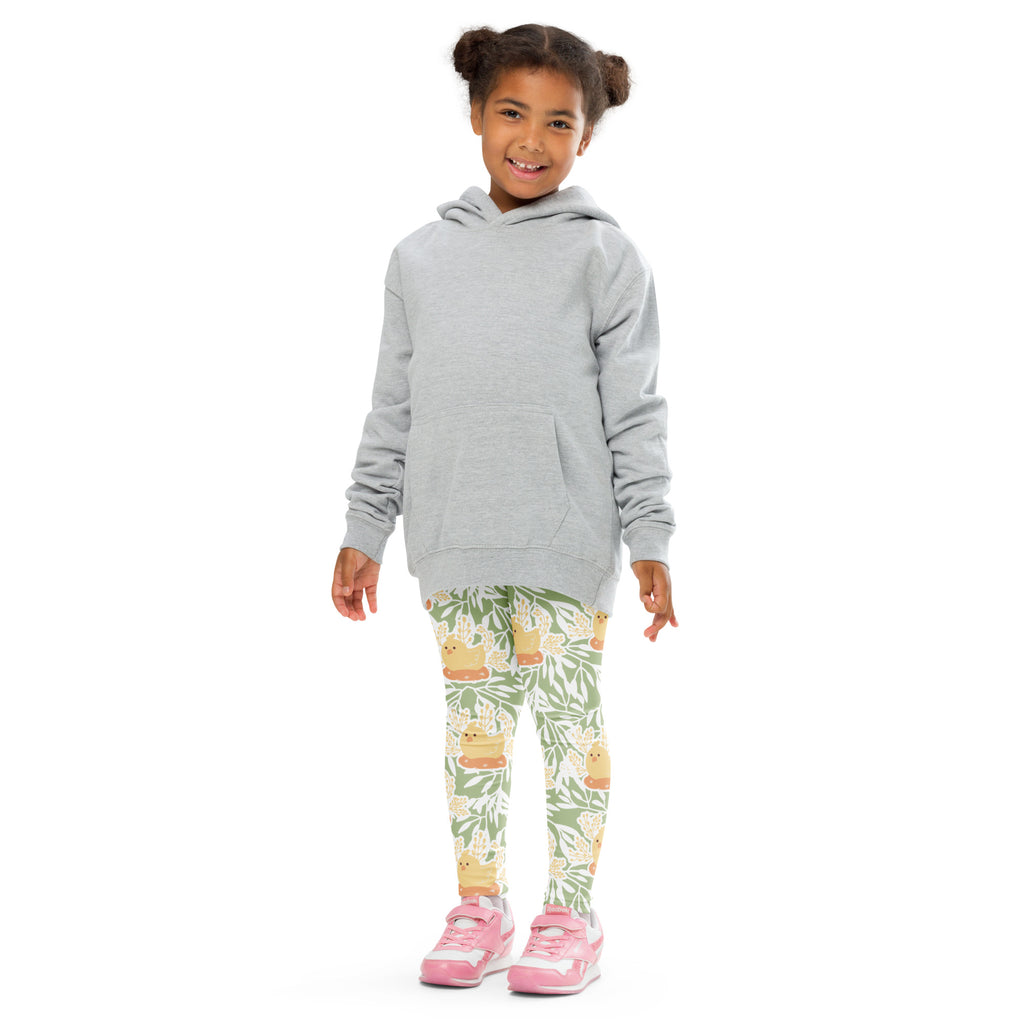 A child wearing girls sage green floral buttery soft leggings with cartoon duck designs paired with a gray hoodie