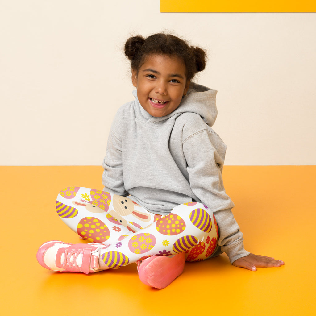 A child wearing girls orange bunny easter egg buttery soft leggings and a gray hoodie with festive patterns