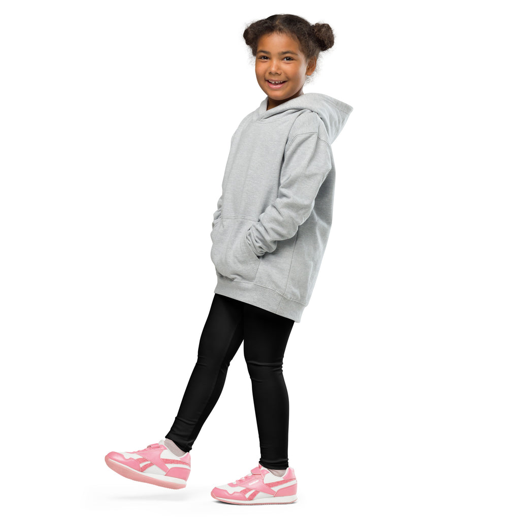 A child wearing buttery soft black leggings and a light gray oversized hoodie with front pockets