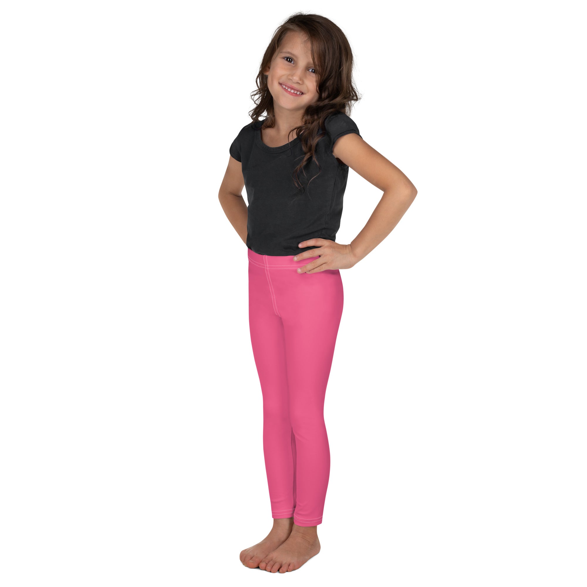 Bright pink buttery soft girls leggings worn by a young girl showing form fitting comfortable fit