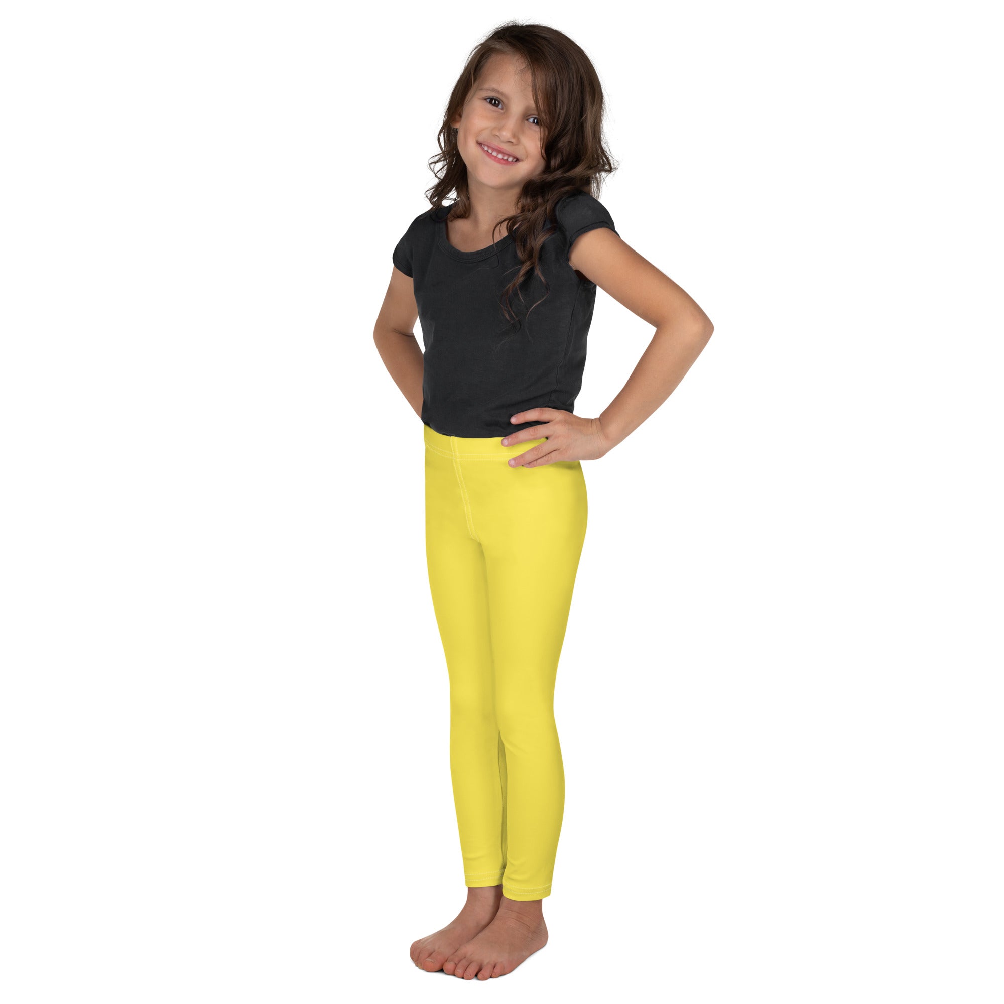 Kids buttery soft yellow leggings worn by a young girl featuring bright yellow form-fitting fabric